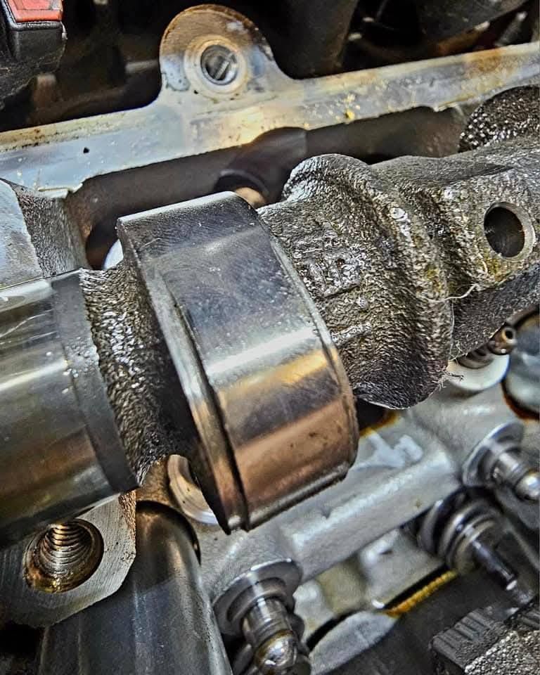 Close-up of an engine camshaft and bearing in a mechanical assembly.