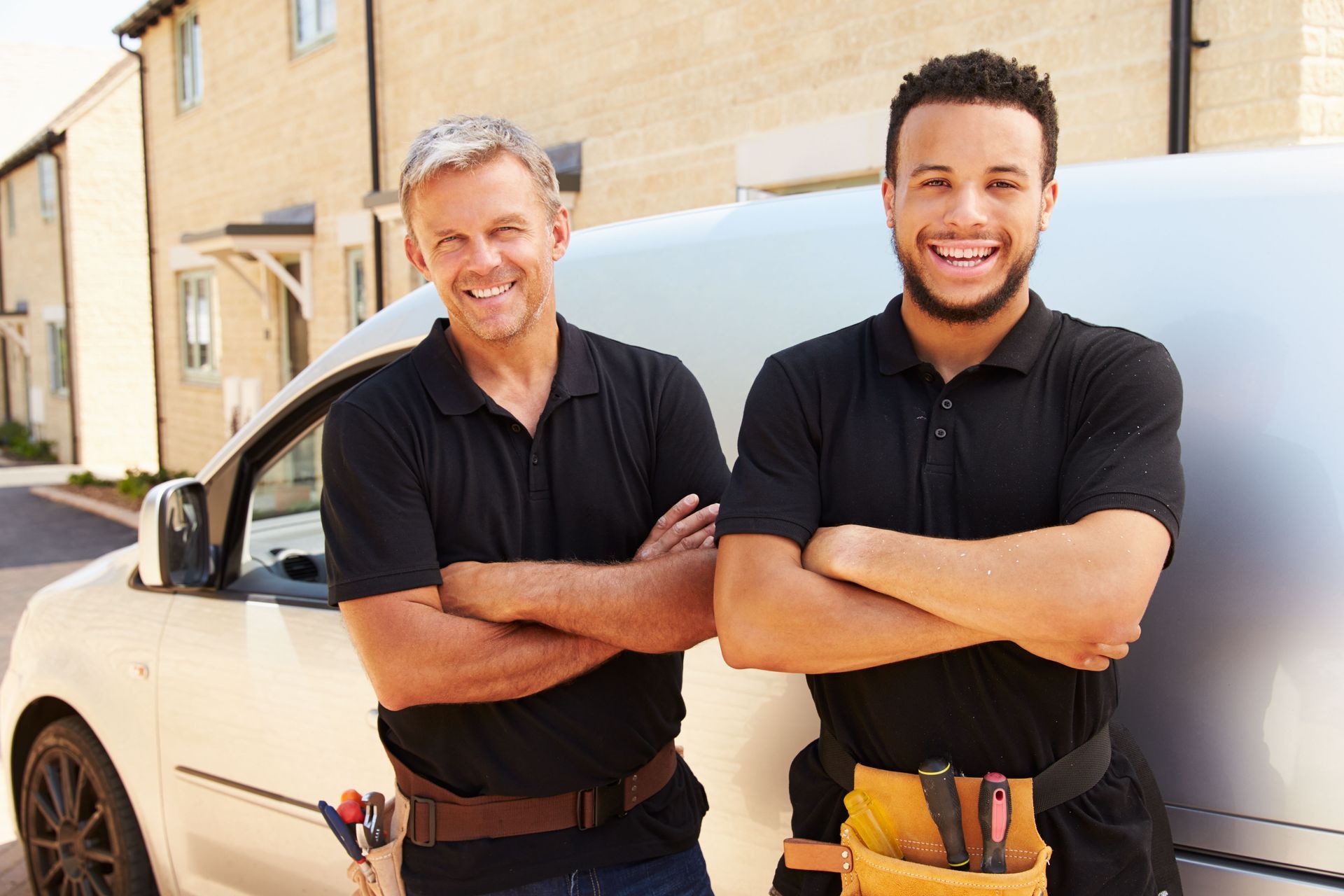 Two men are standing next to each other in front of a van.