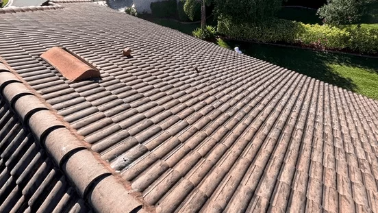 Terracotta tile roof with a skylight, viewed from above in sunlight