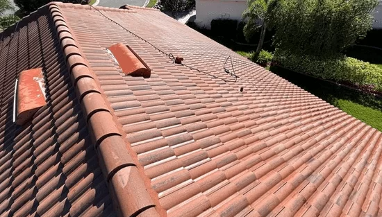 Terracotta tile roof with several skylights, viewed from above in bright sunlight