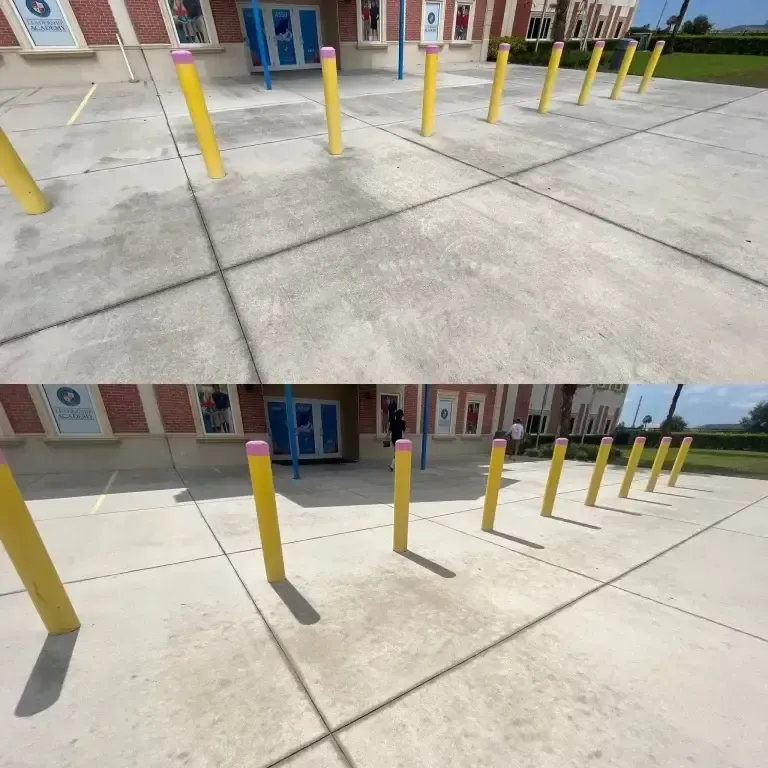 Yellow bollards on a concrete walkway outside a building with blue doors and windows.