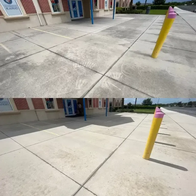 School building entrance with blue doors and a yellow bollard on a concrete sidewalk.