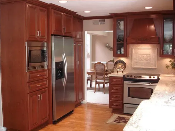 Kitchen with brown cabinets, stainless steel refrigerator and appliances, and a view into the dining room.