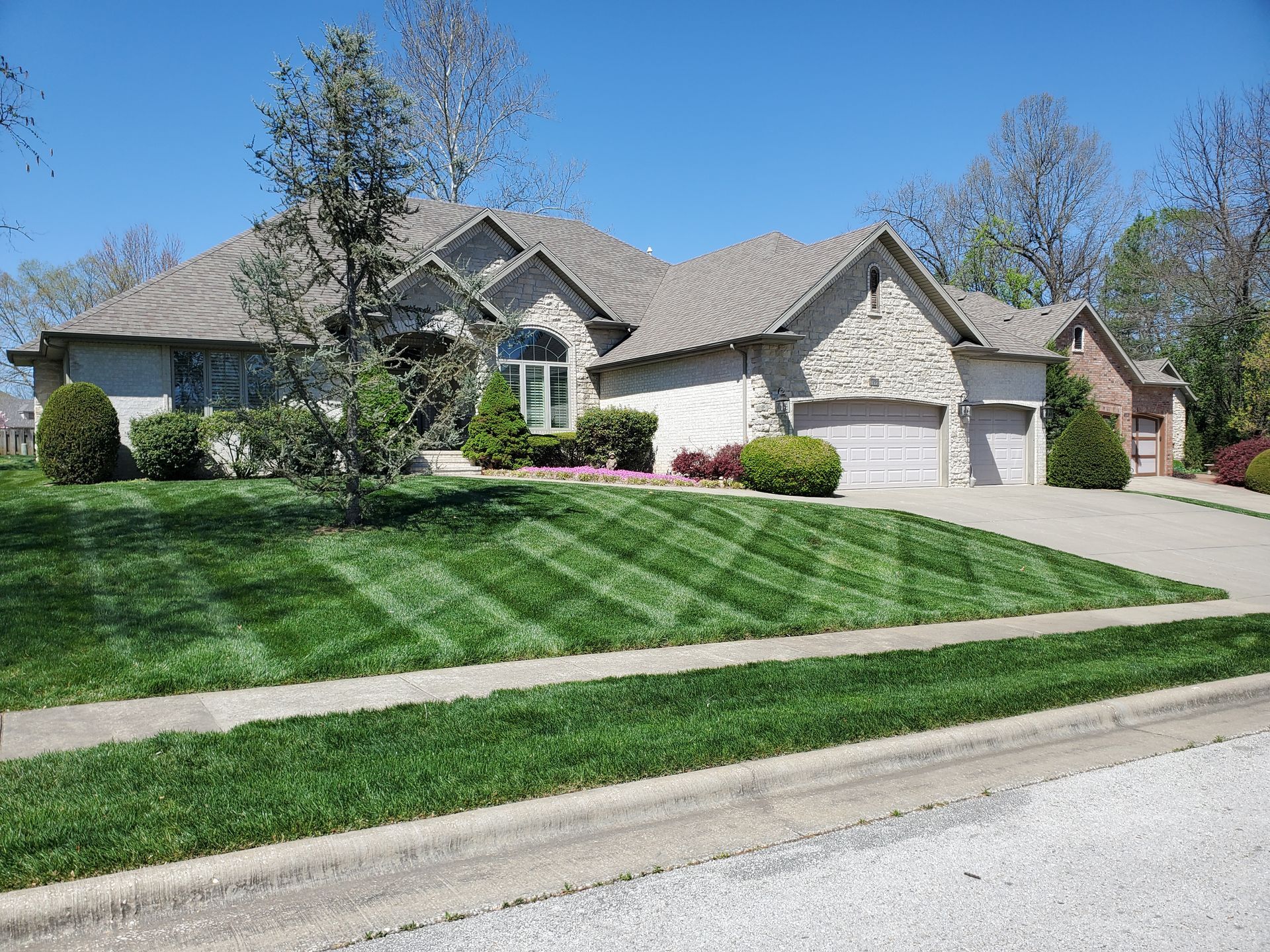 A large house with a beautiful lawn in front of it