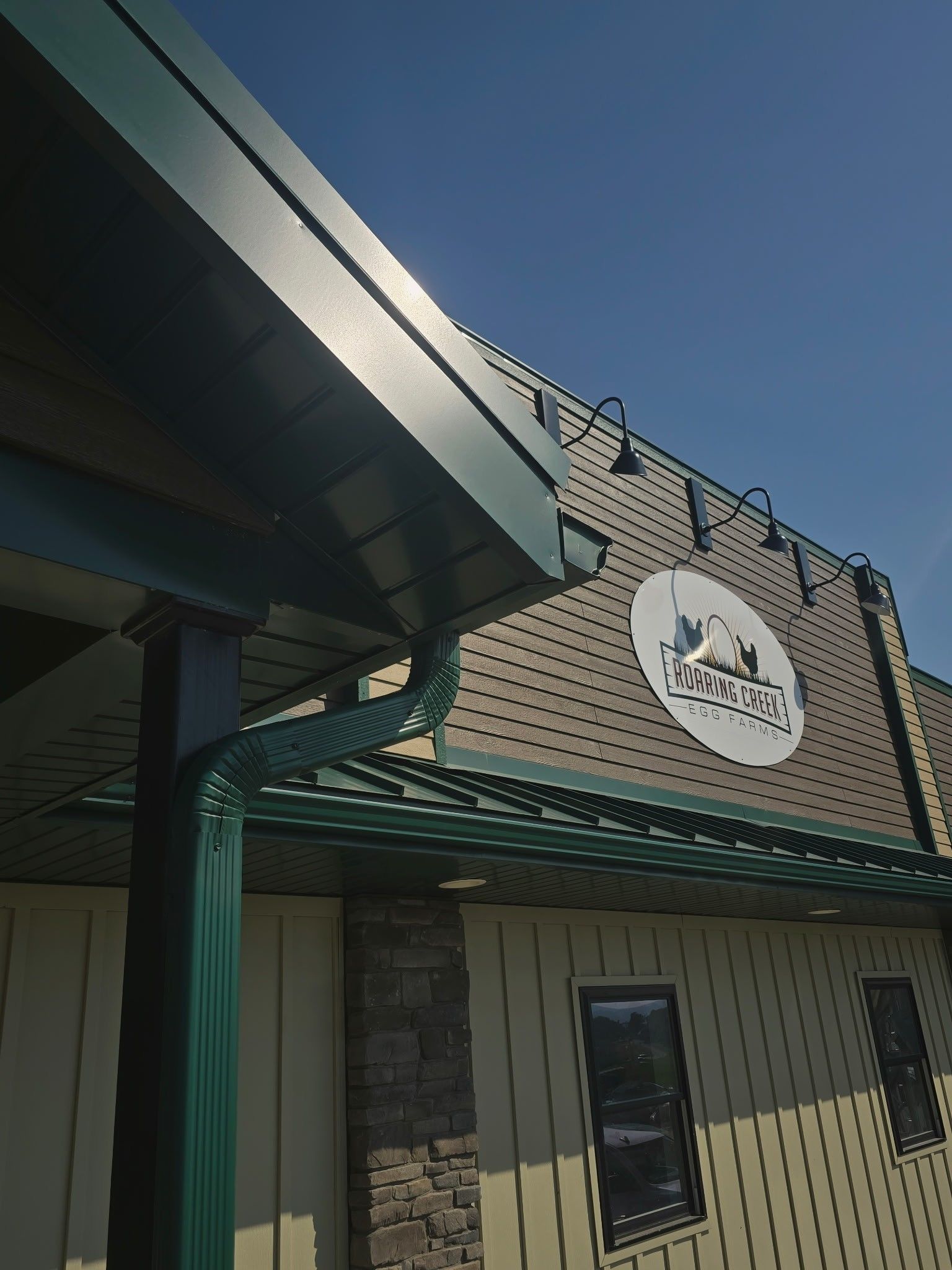 Building exterior with green awning and a round sign above the entrance.