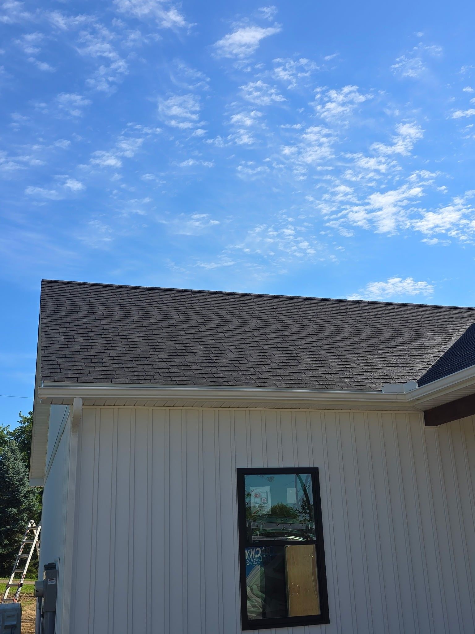 White house exterior with dark gray roof against a blue sky