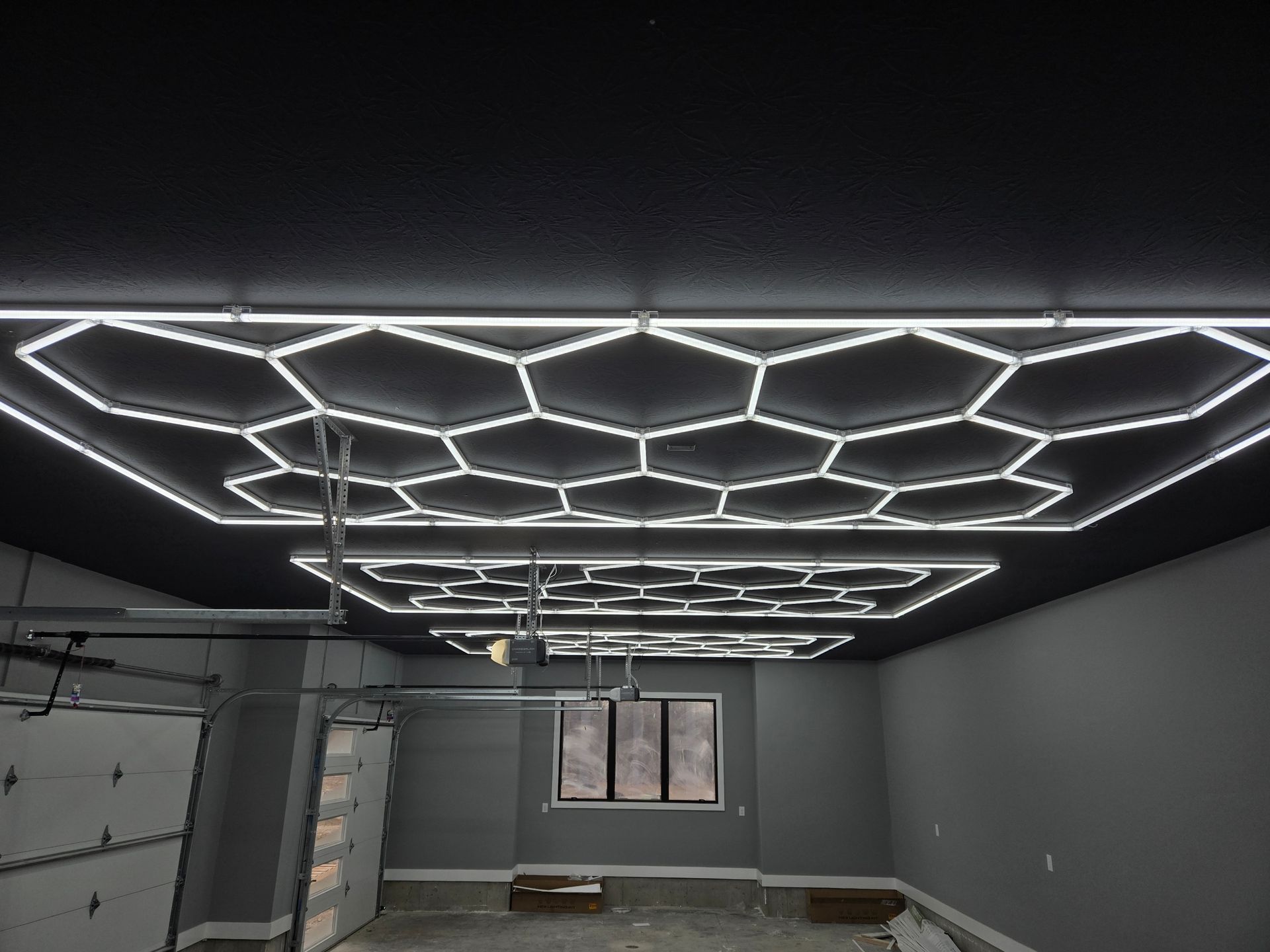 Garage with honeycomb-shaped ceiling lights, contrasting with a dark ceiling.