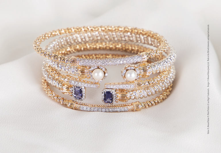 A close up of a stack of bracelets on a white surface.