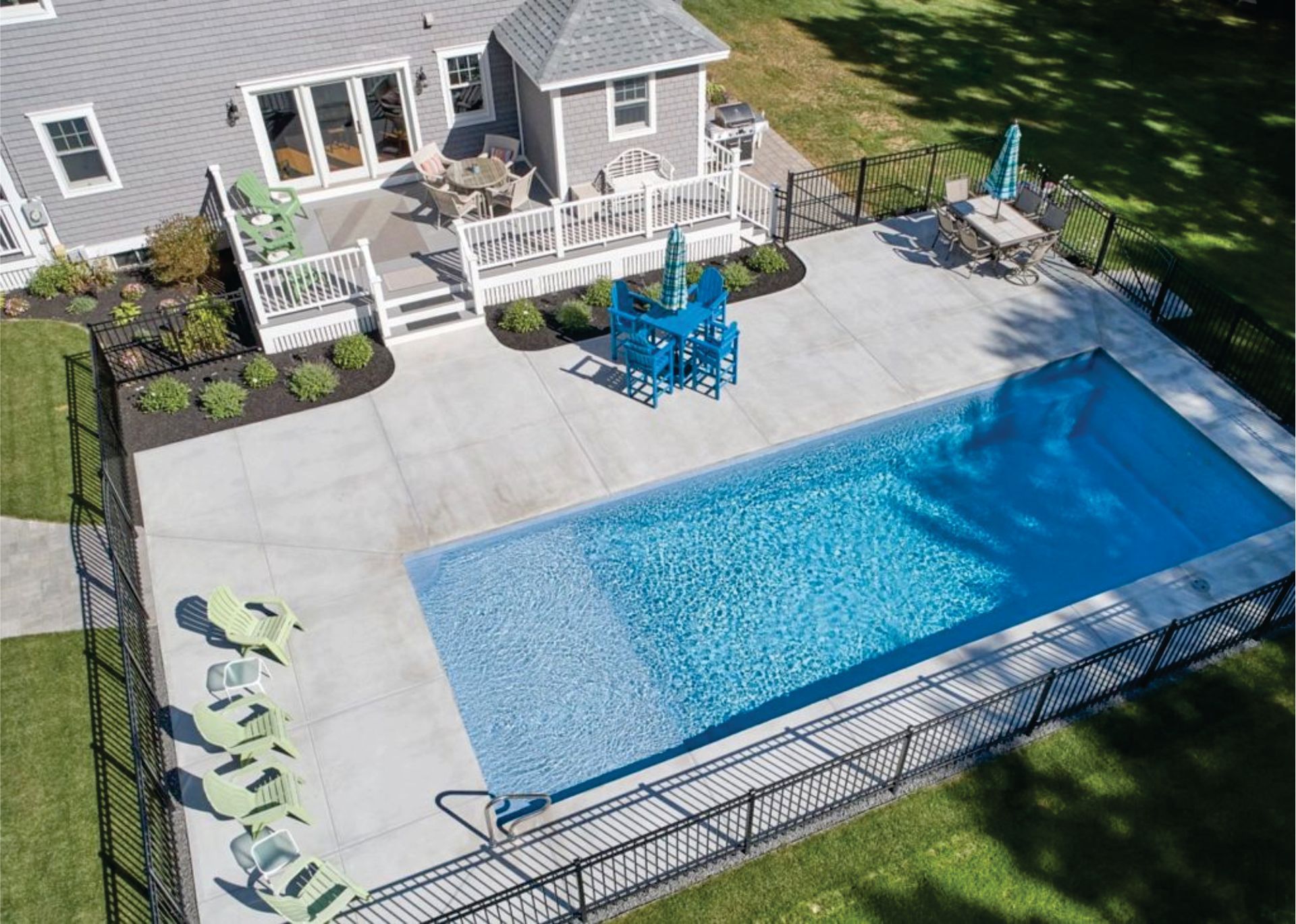 an aerial view of a large swimming pool in front of a house