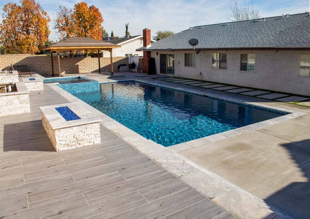 there is a large swimming pool in the backyard of a house