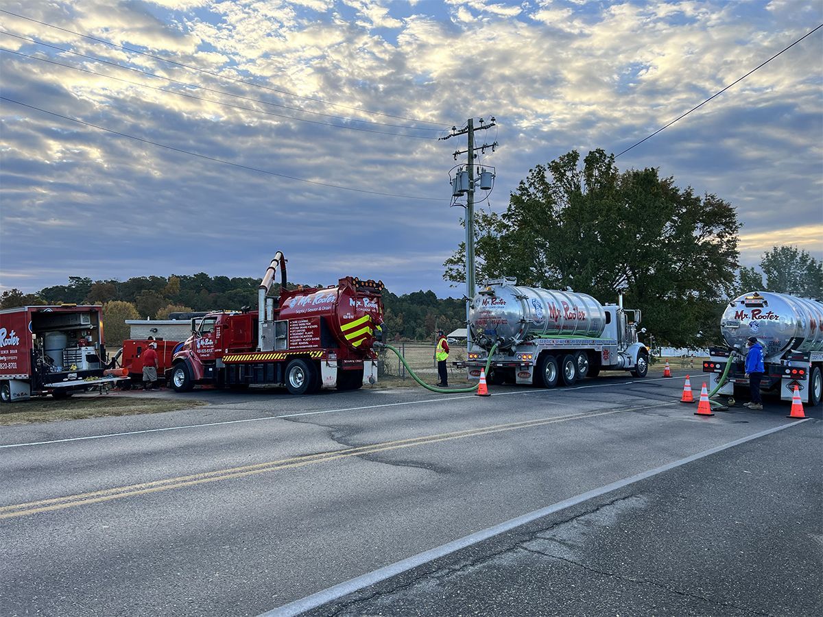 Roadside semi-truck crash cleanup with tow trucks, cones, and workers on a cloudy highway.