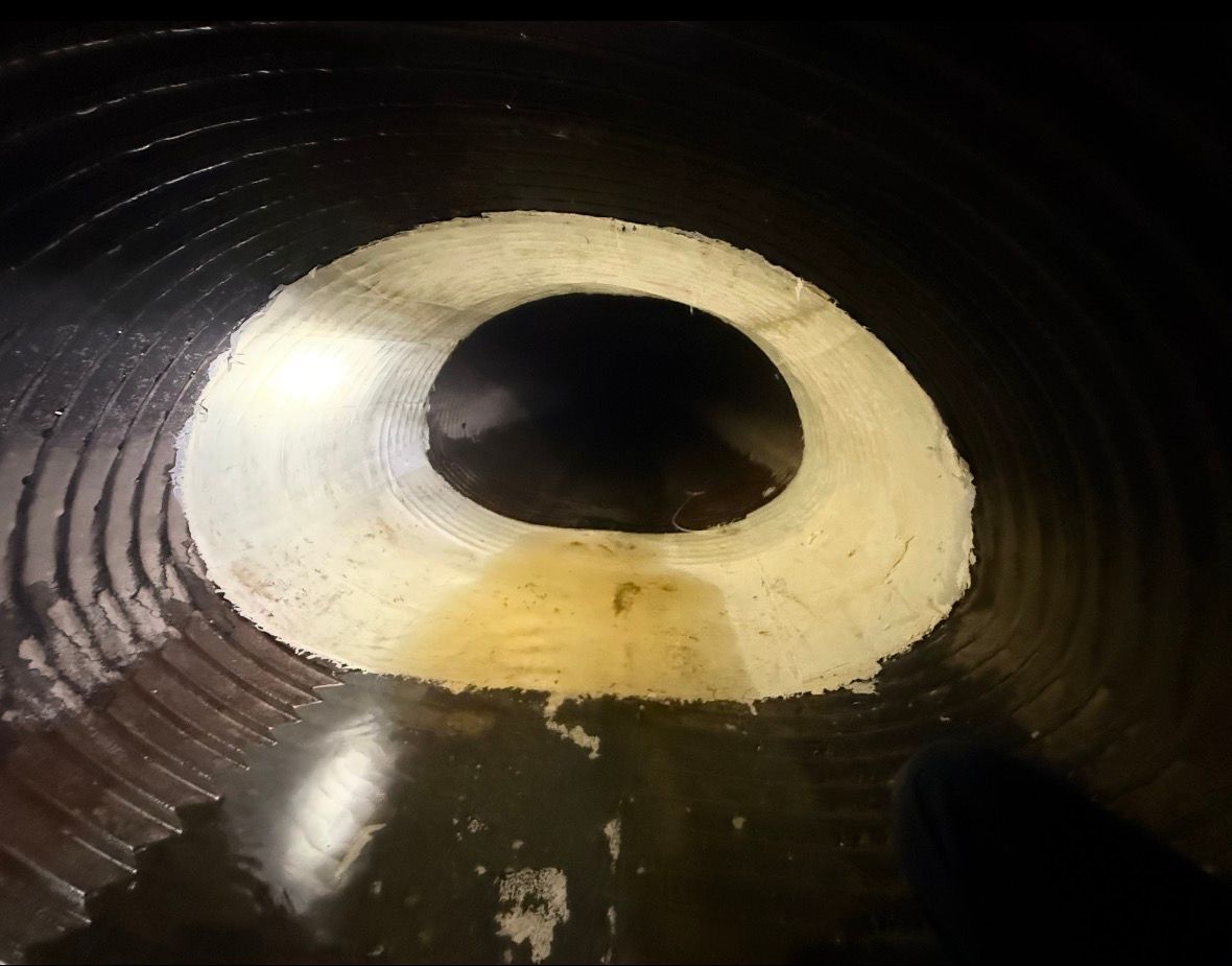 Inside a dark cylindrical tunnel, a pale circular opening with a black center is visible.