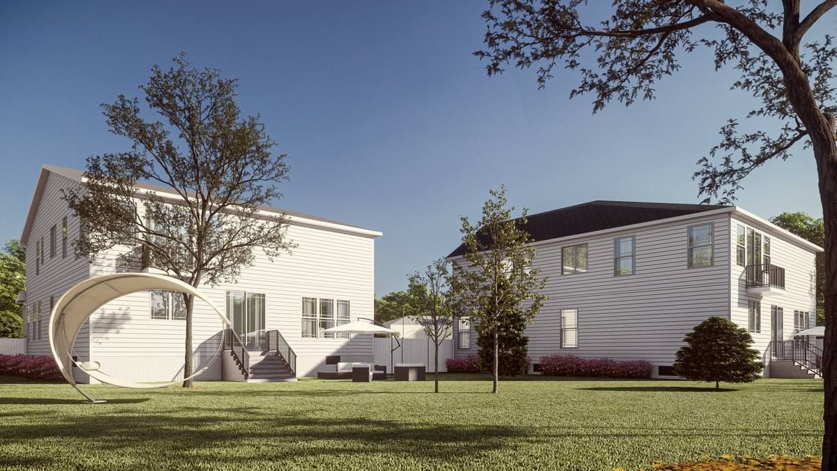 Two white suburban houses with a lawn and trees under a clear blue sky