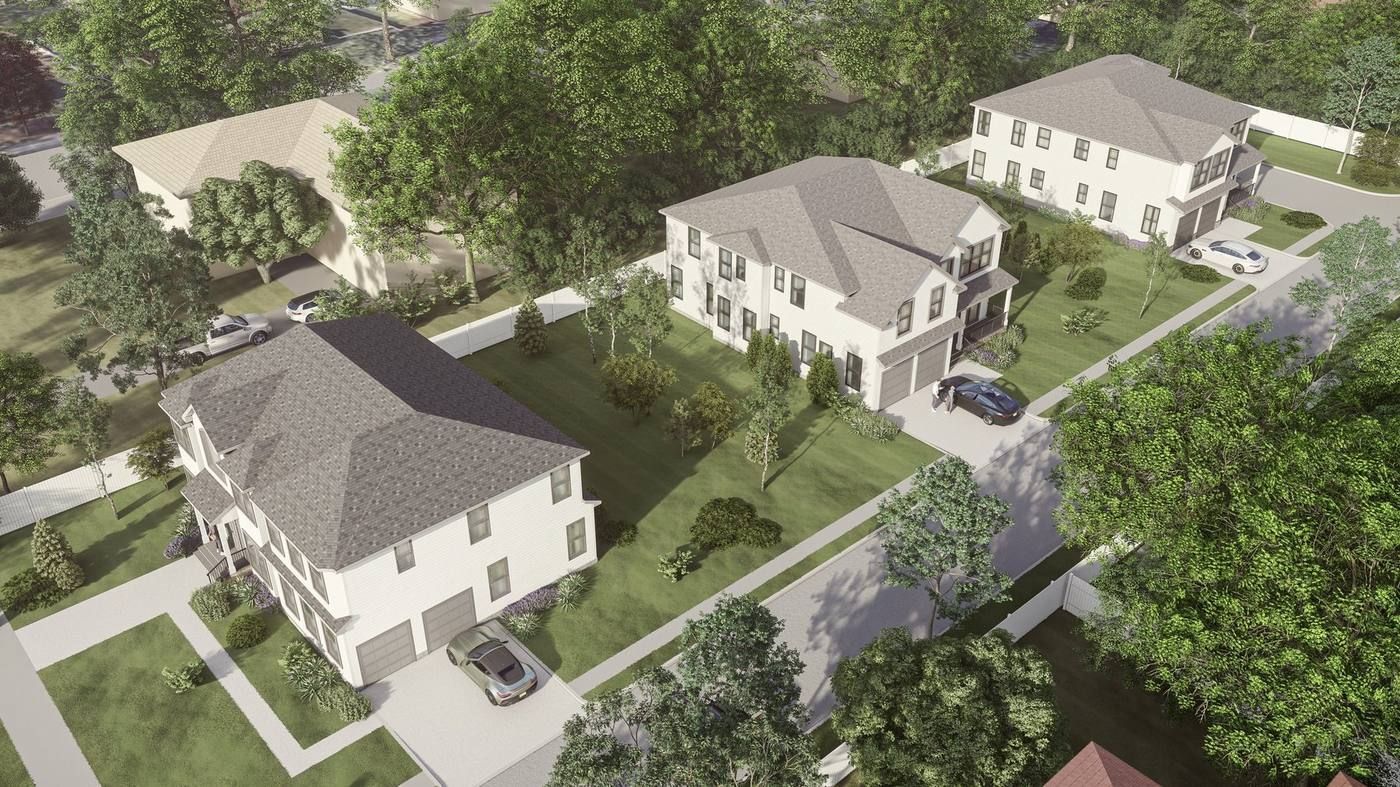 Aerial view of a suburban neighborhood with white houses, trees, sidewalks, and parked cars.