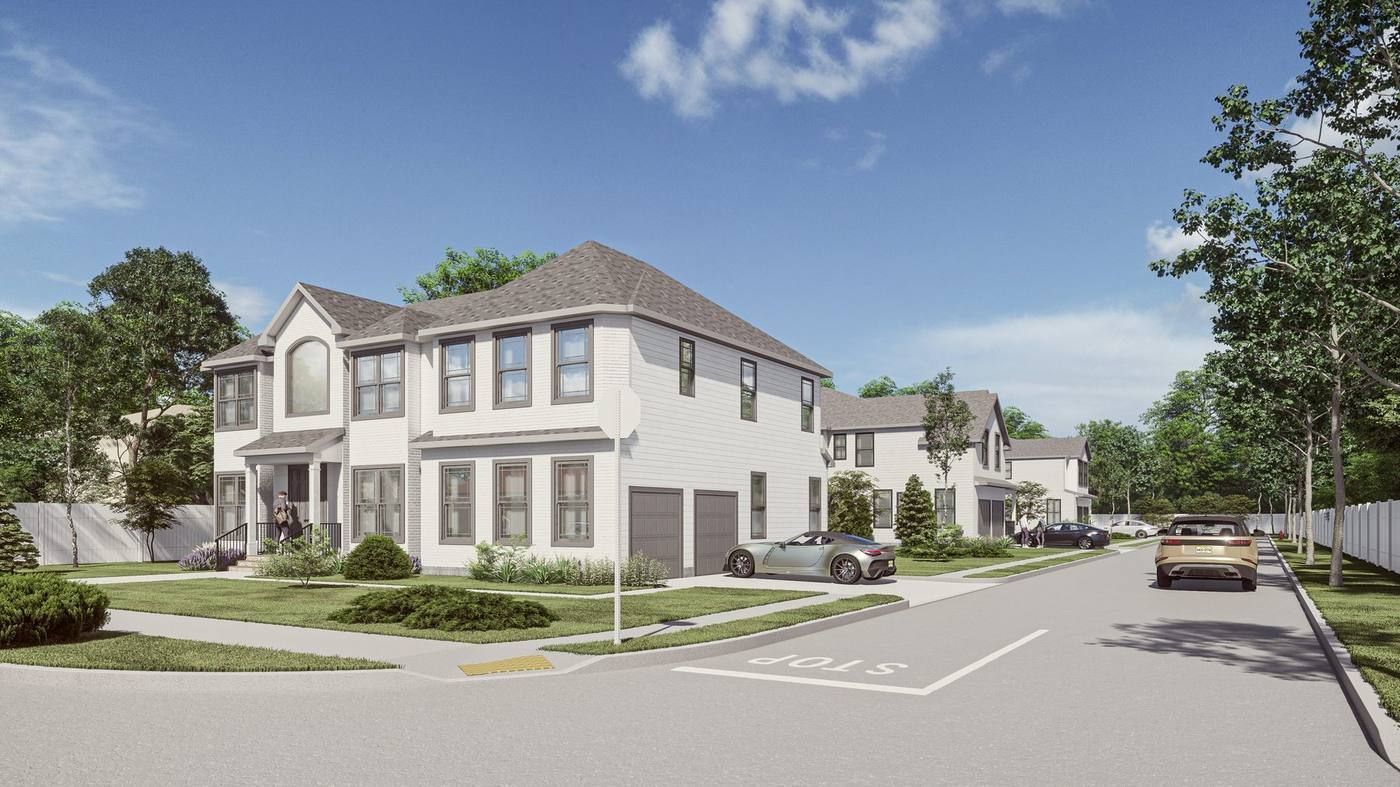 Modern suburban townhouses on a quiet street under a blue sky