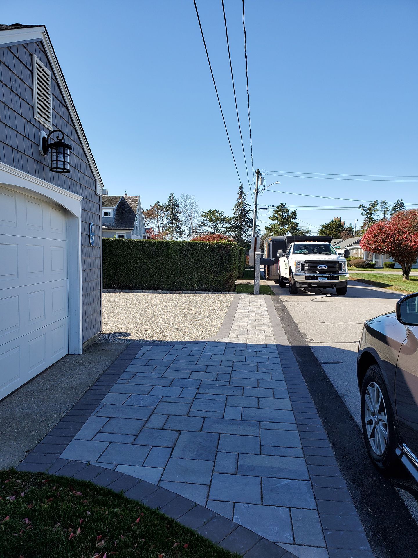 A white truck is parked in front of a garage.