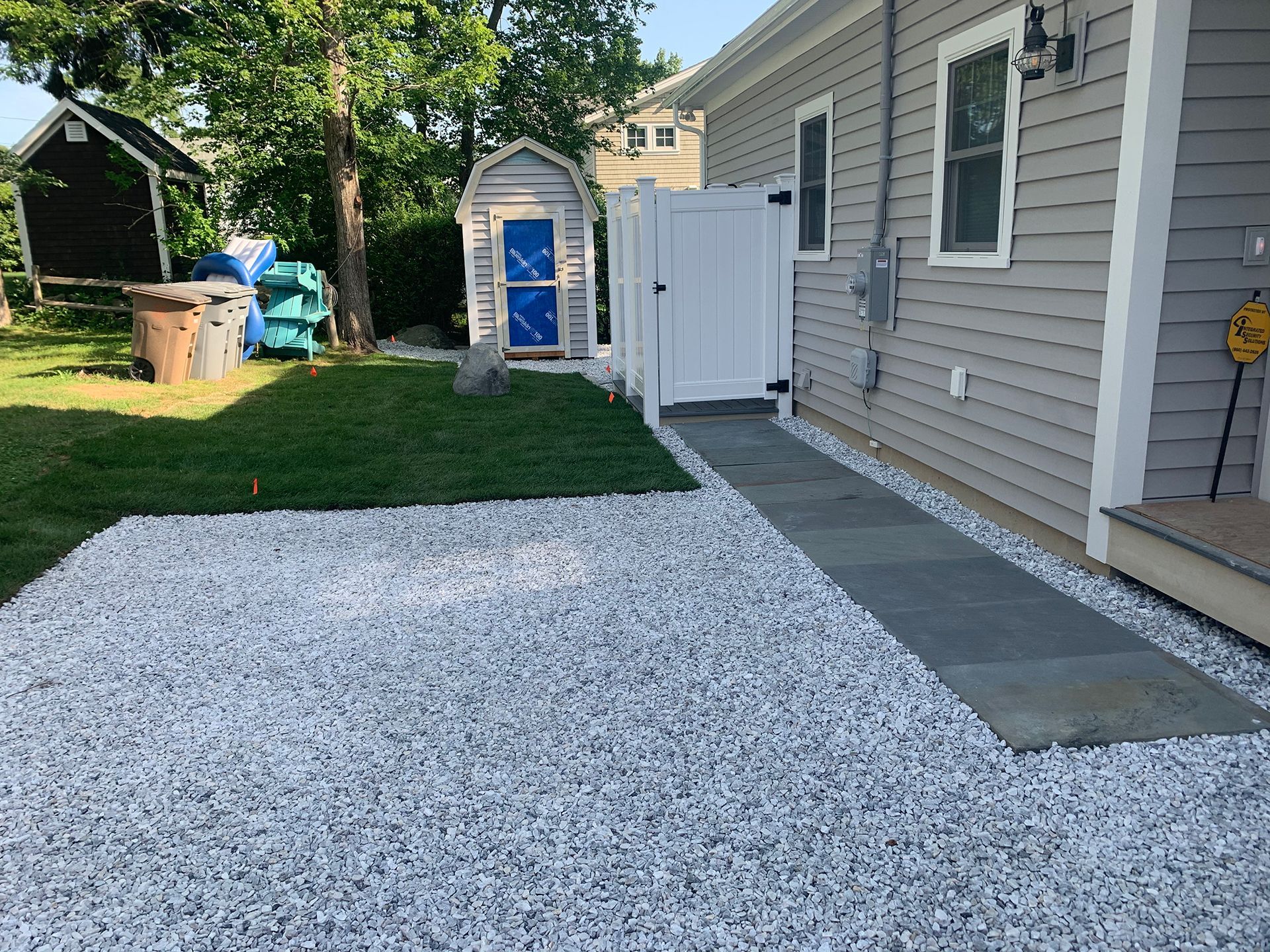 A house with a walkway and a shed in the backyard
