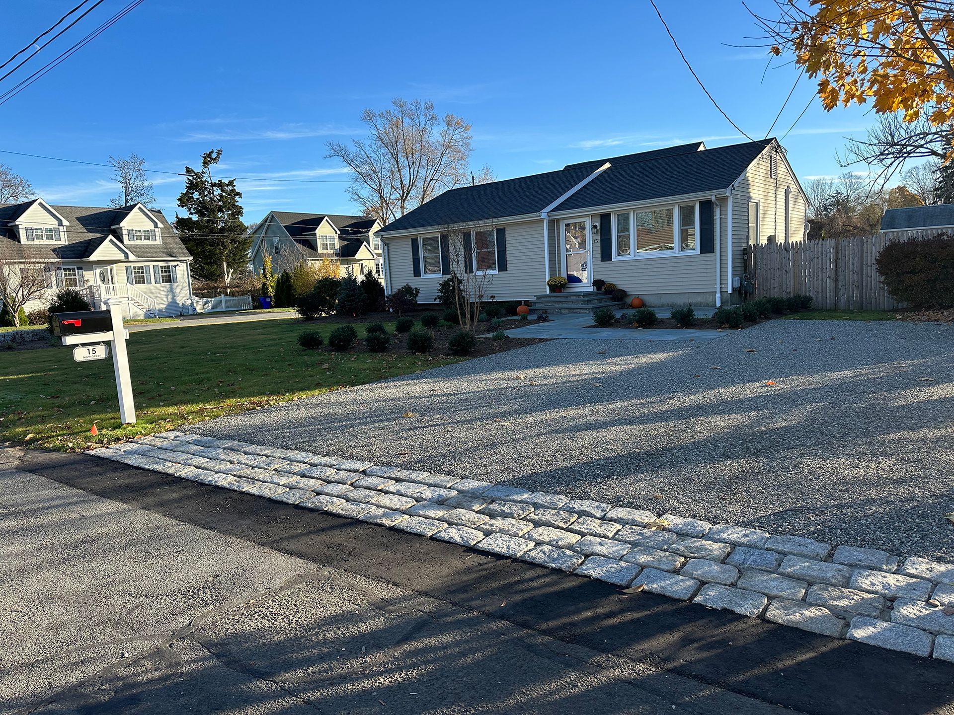 A house with a gravel driveway and a mailbox in front of it.