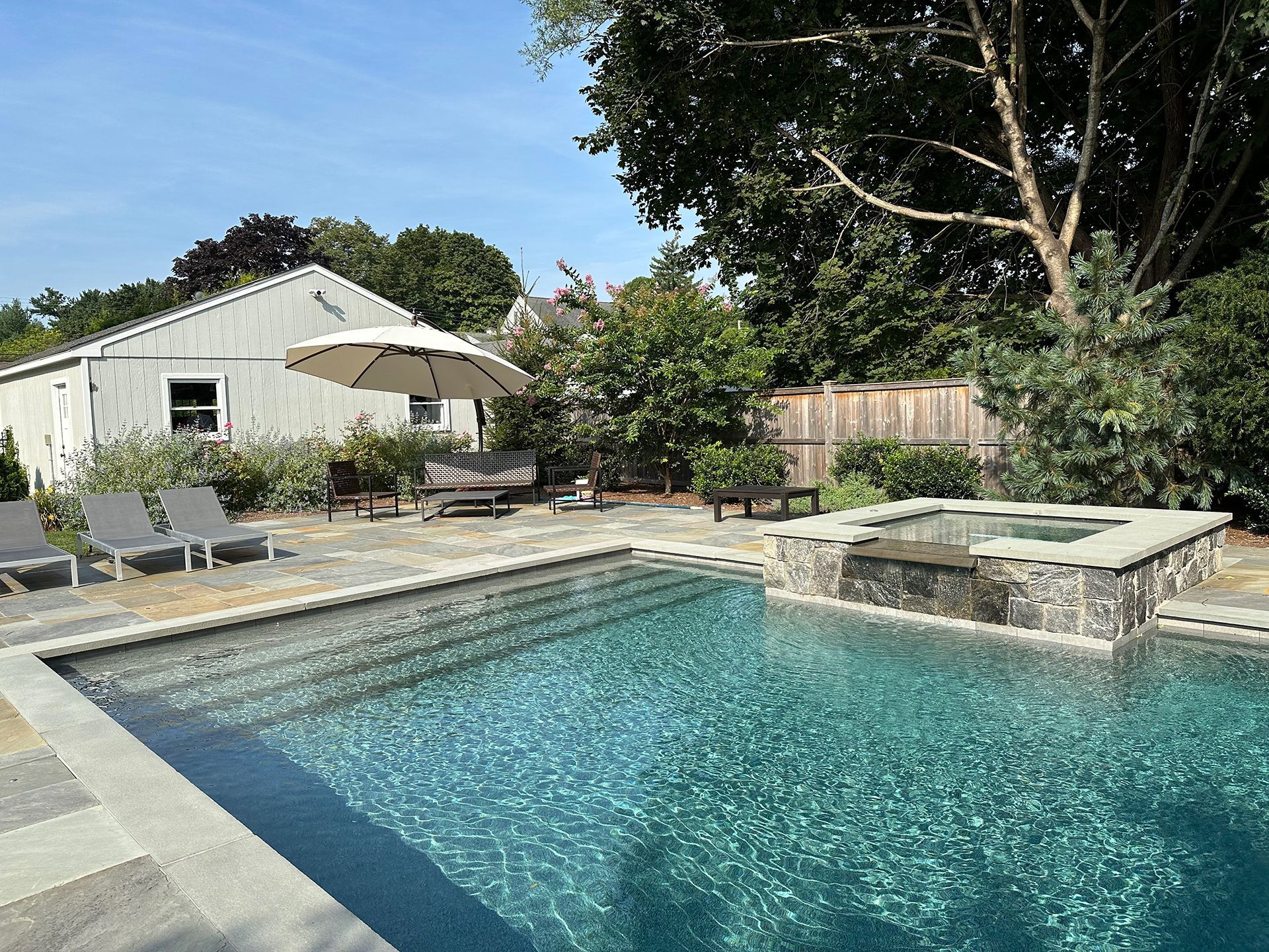 A large swimming pool in a backyard with a house in the background