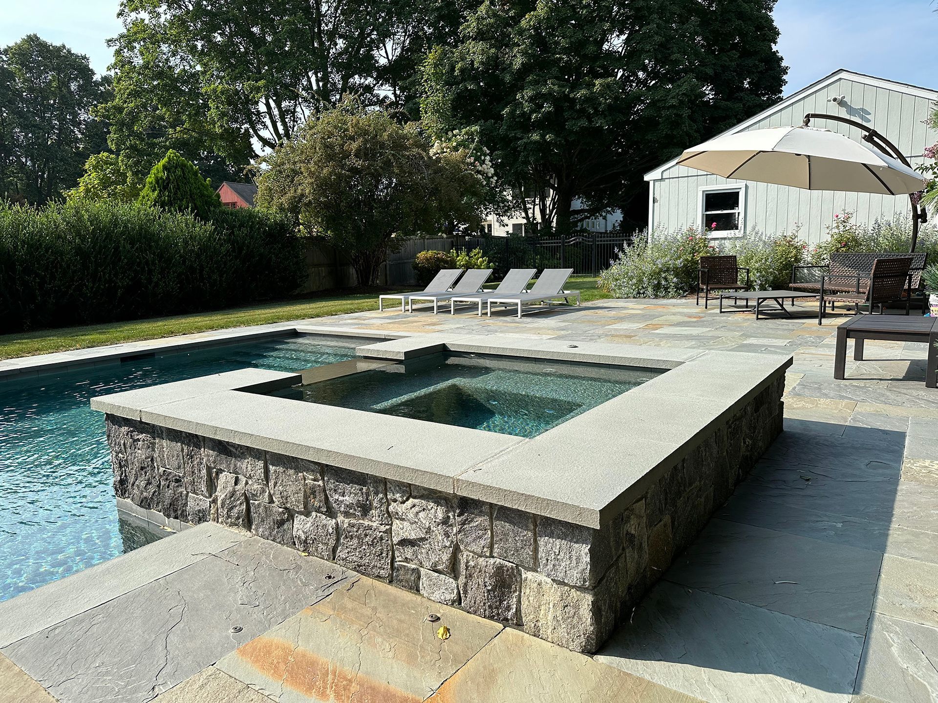 A large swimming pool with a hot tub in the middle
