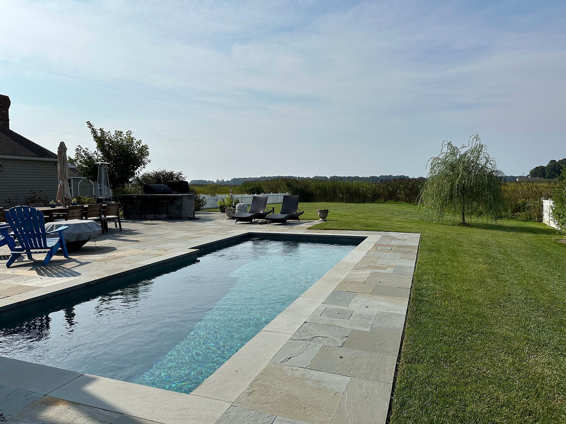 A large swimming pool surrounded by chairs and umbrellas