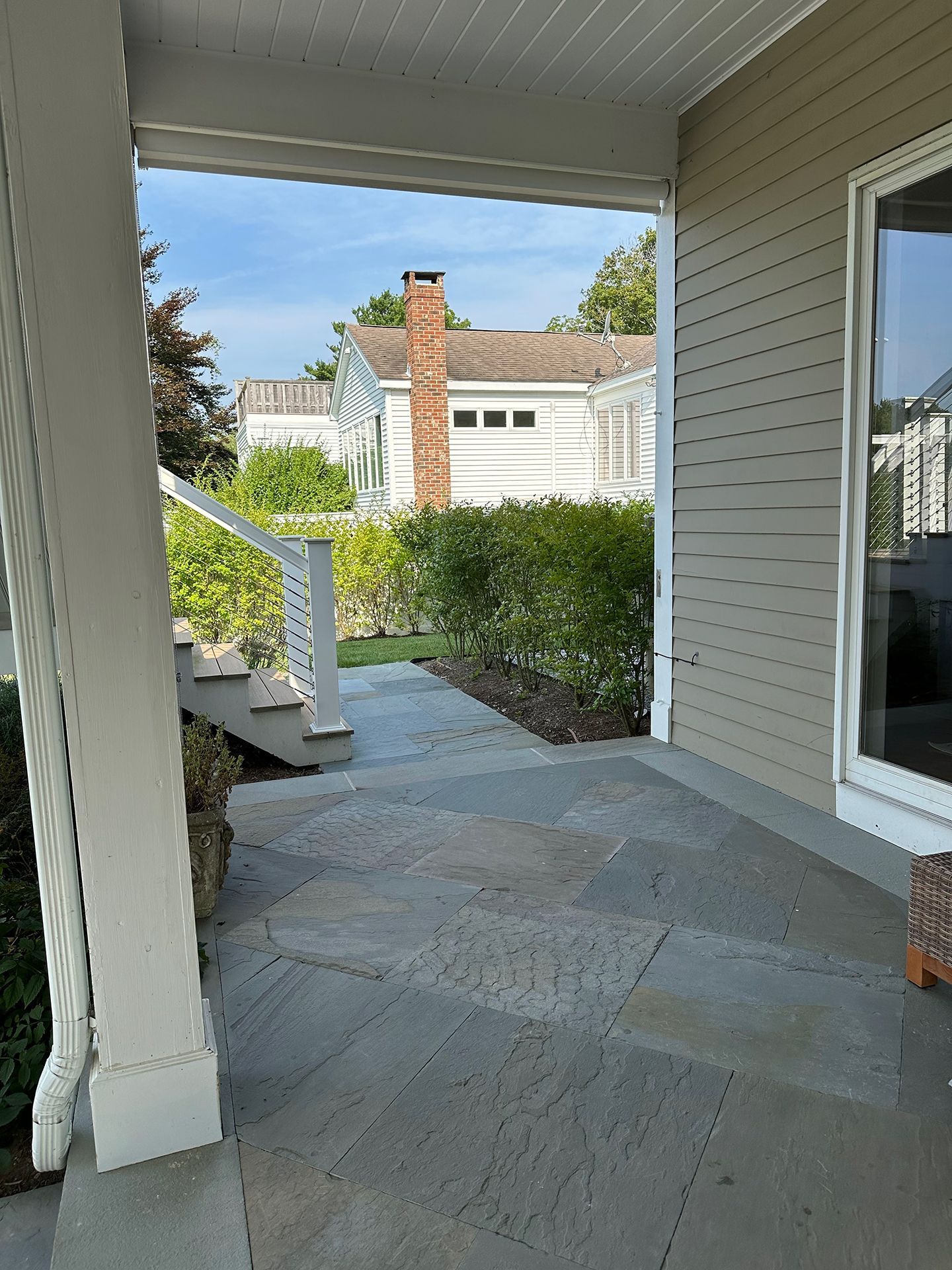 A porch with a staircase leading up to a house.