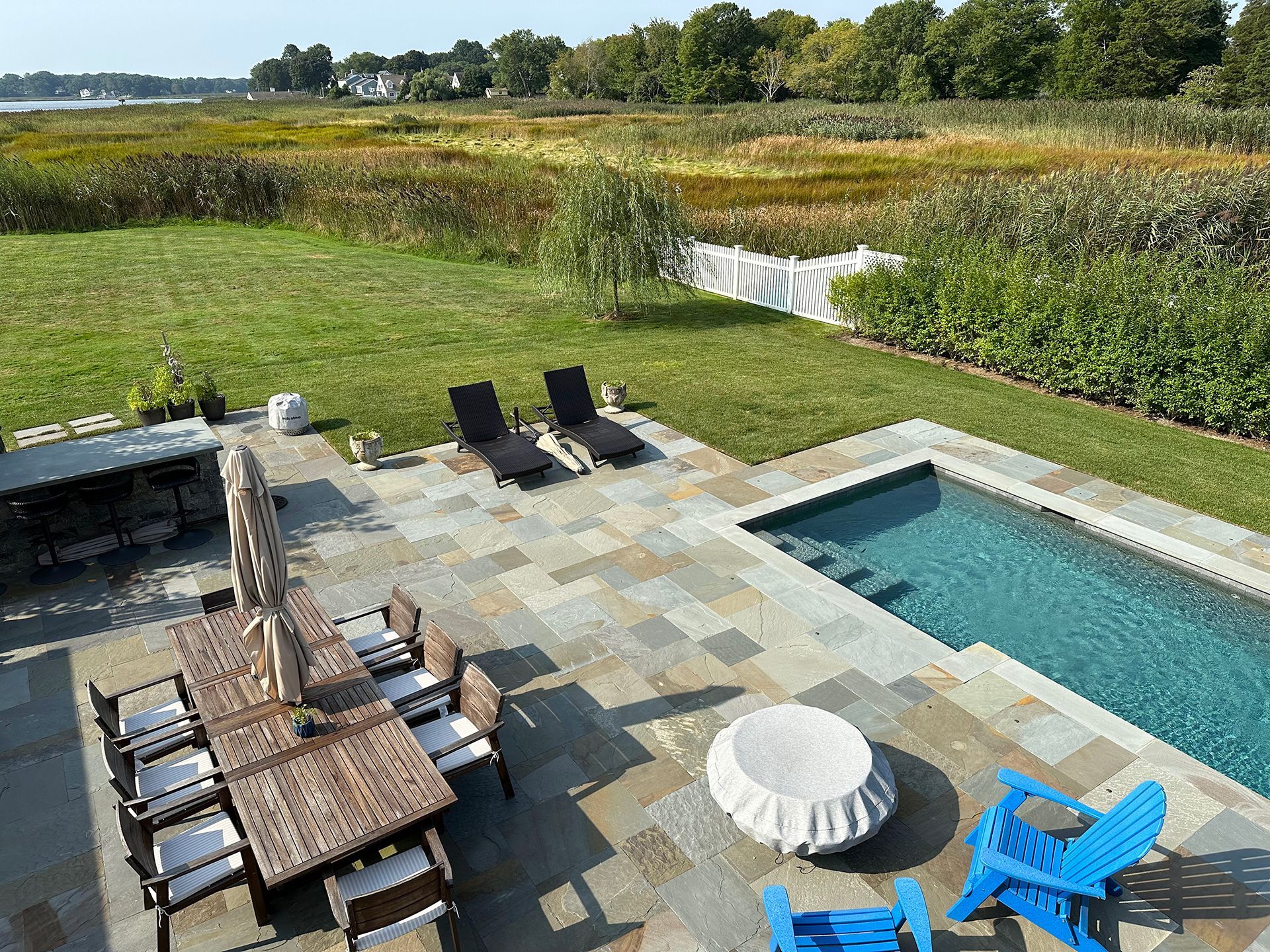 An aerial view of a patio with a table and chairs and a pool.