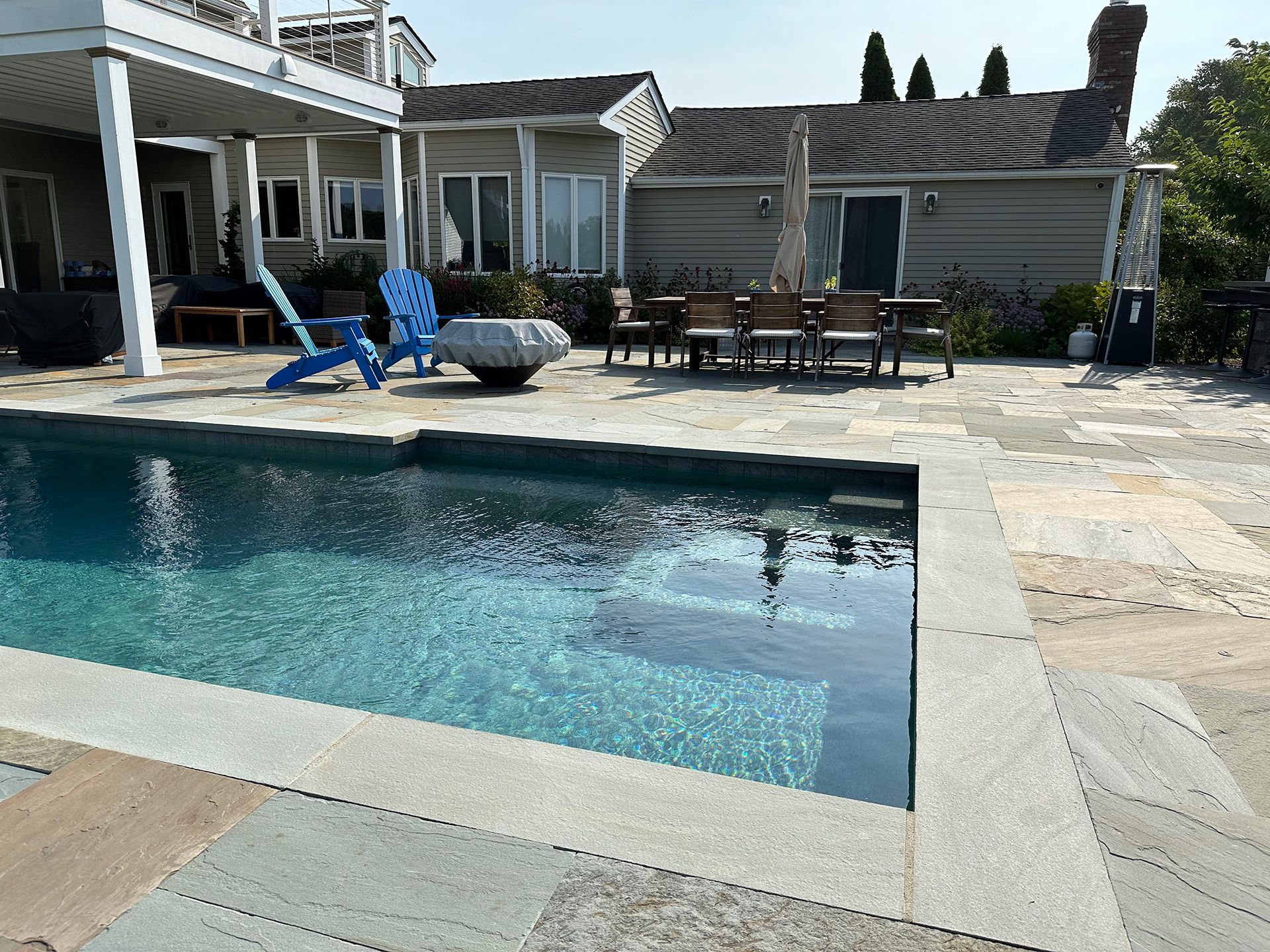 A large swimming pool in front of a house