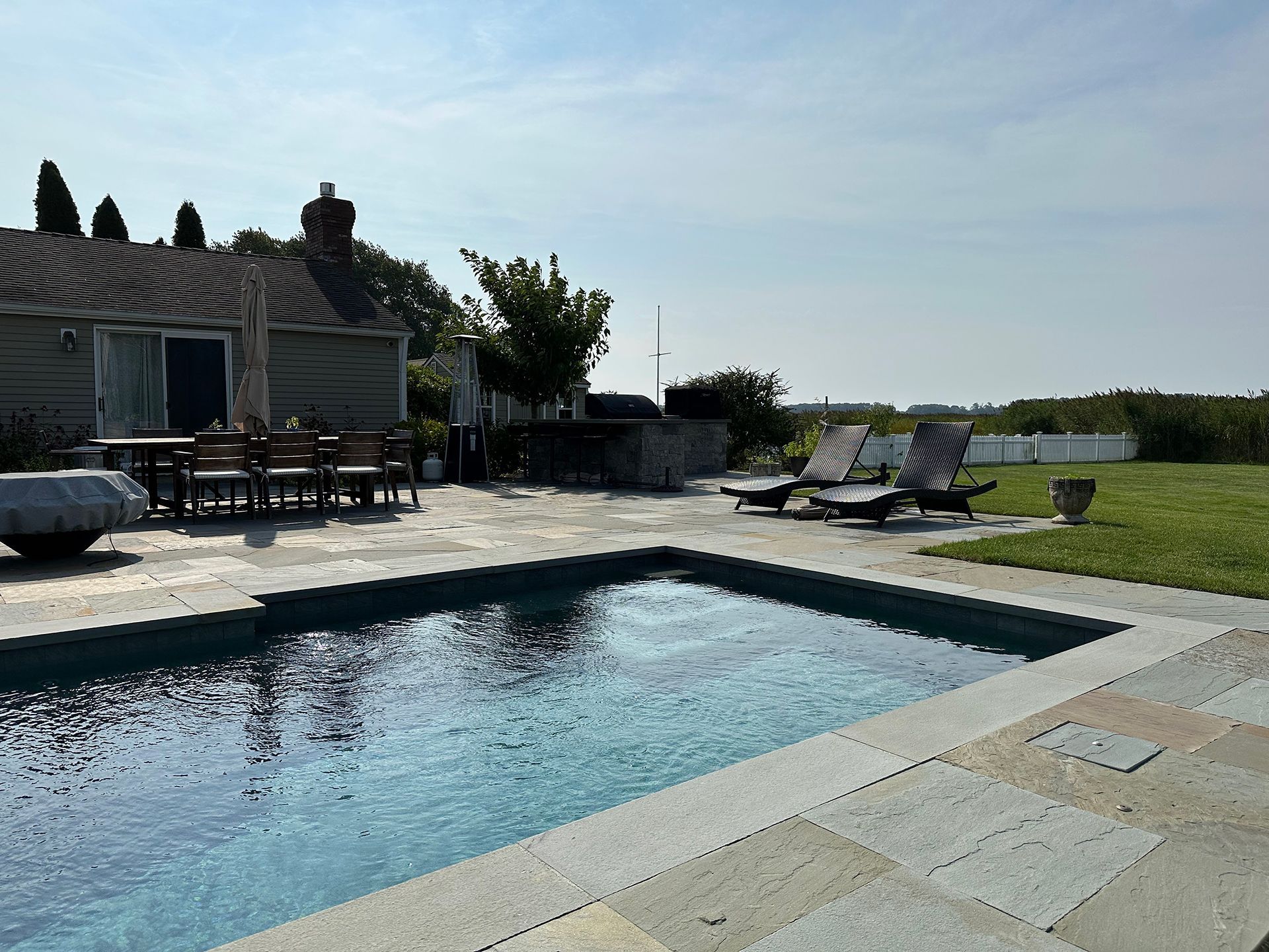 A large swimming pool with a house in the background