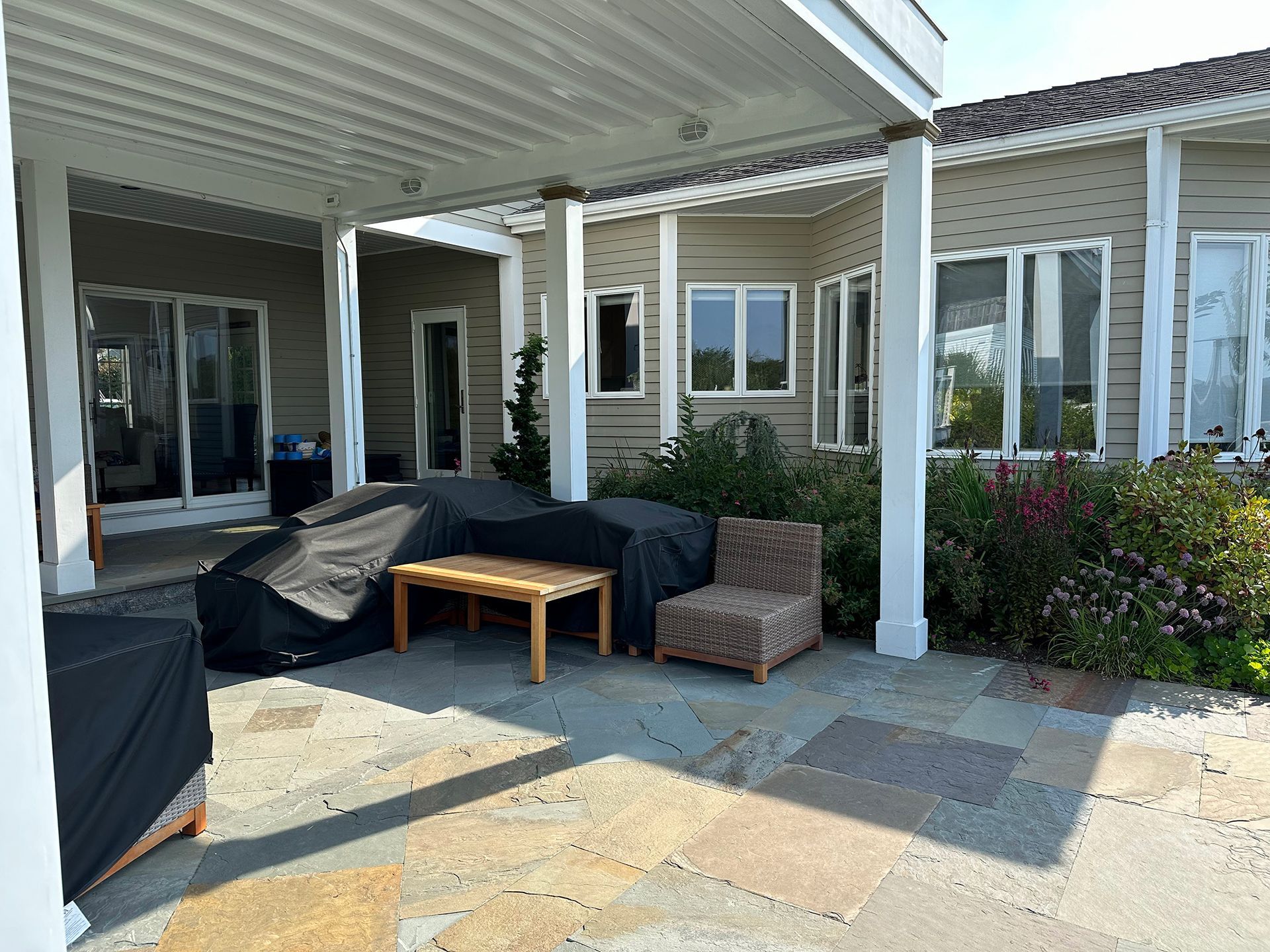 A patio with a table and chairs under a pergola.