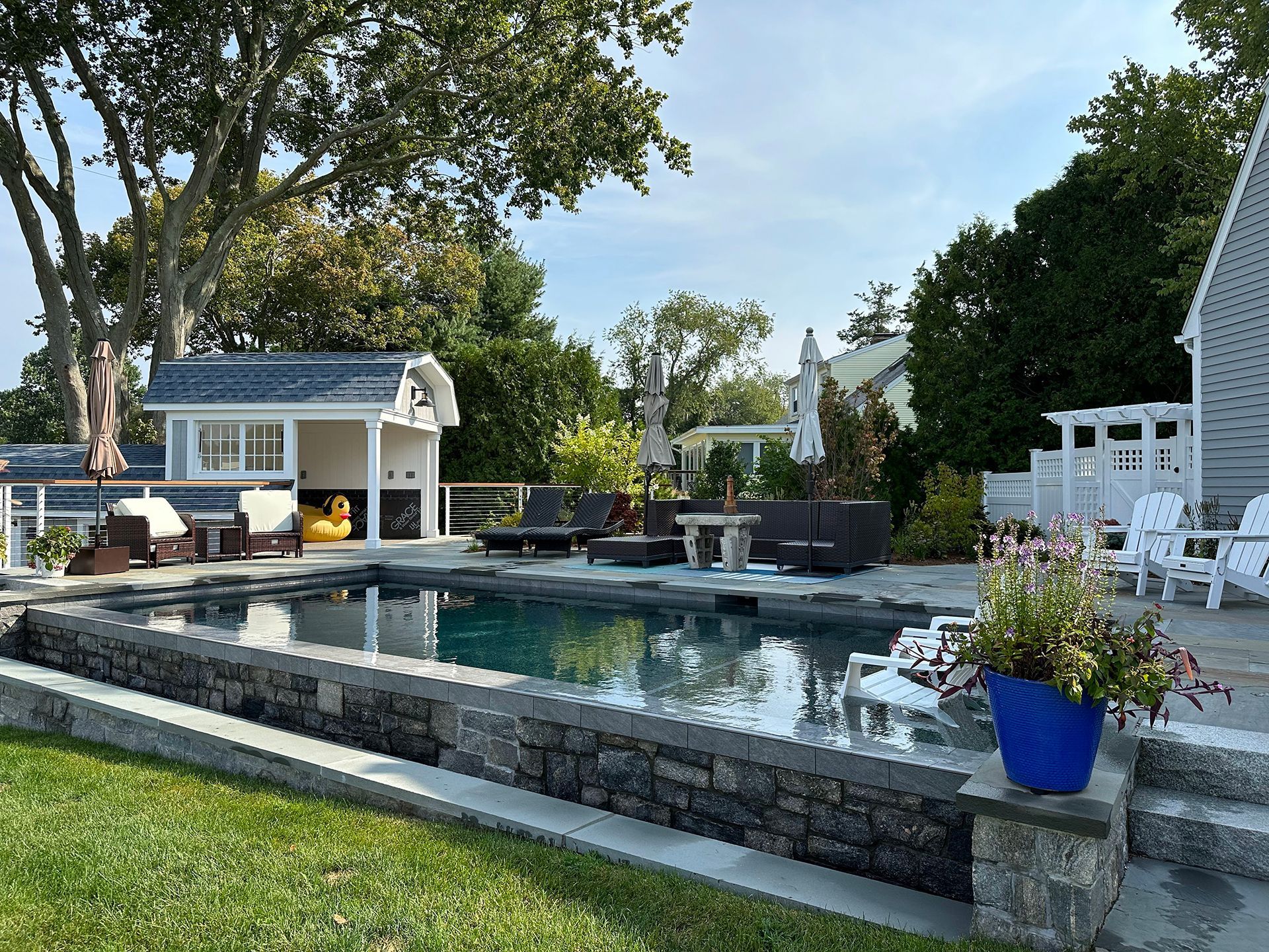 A large swimming pool is in the backyard of a house