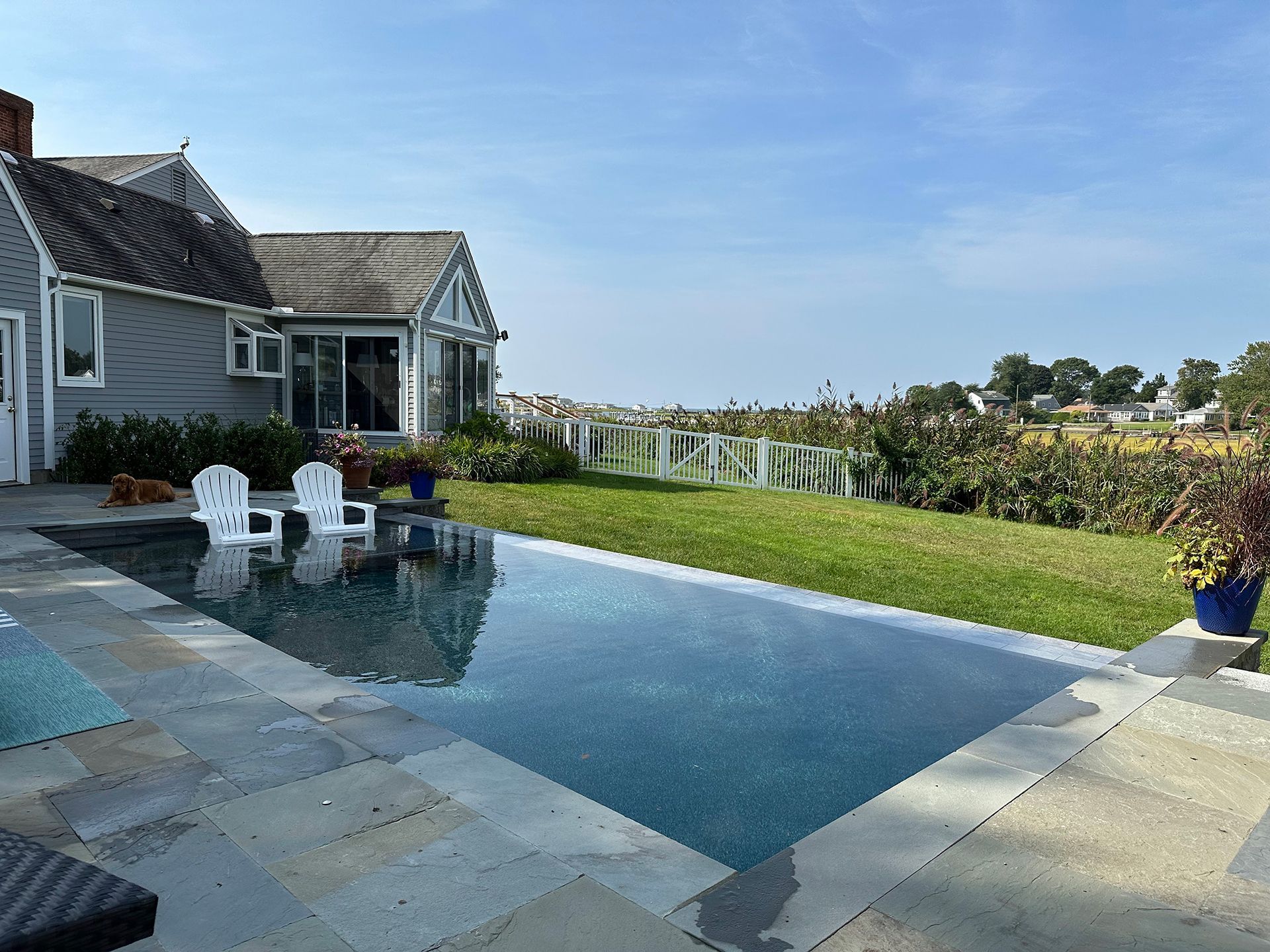 A house with a large swimming pool in front of it
