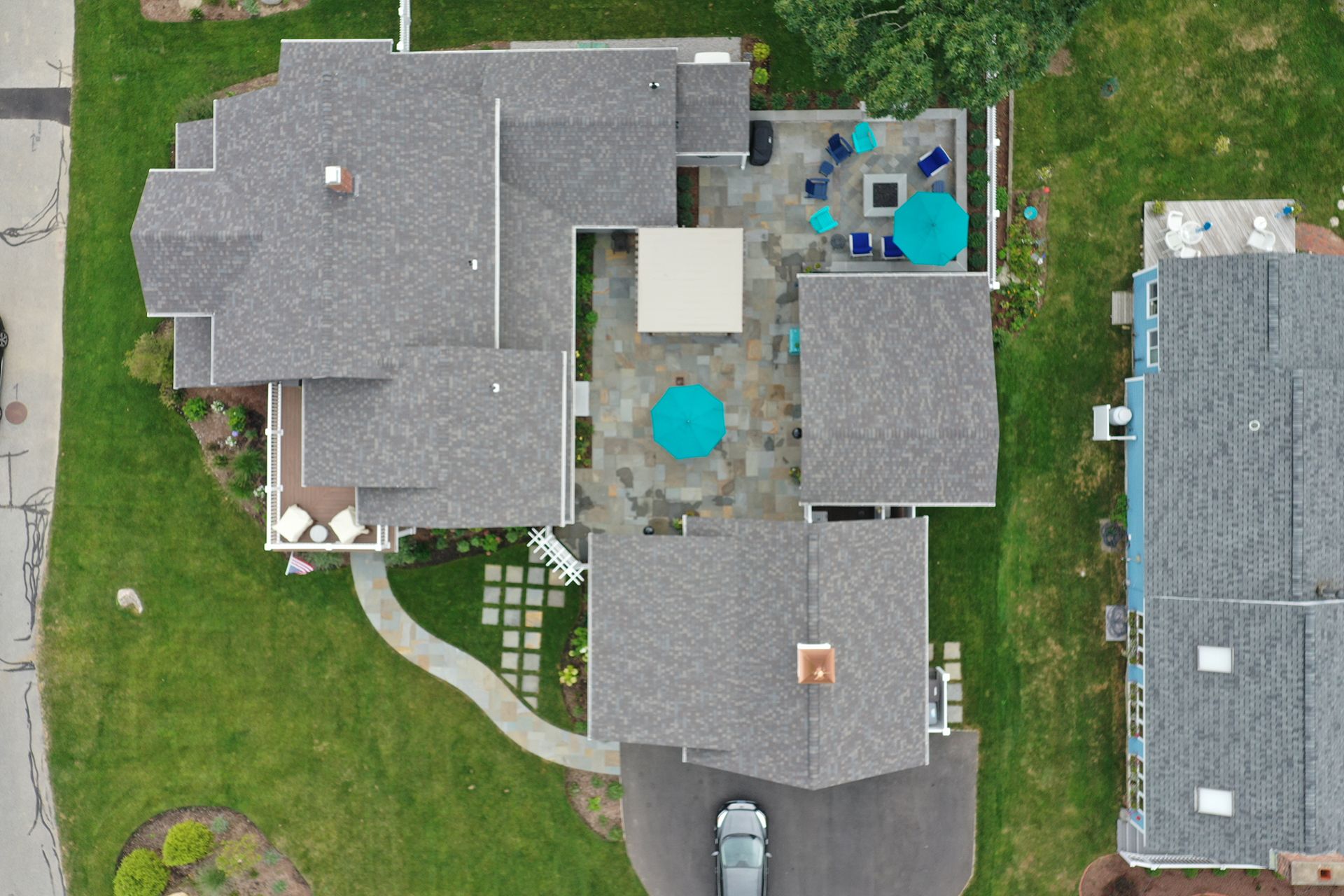 An aerial view of a house with a blue umbrella on the patio.