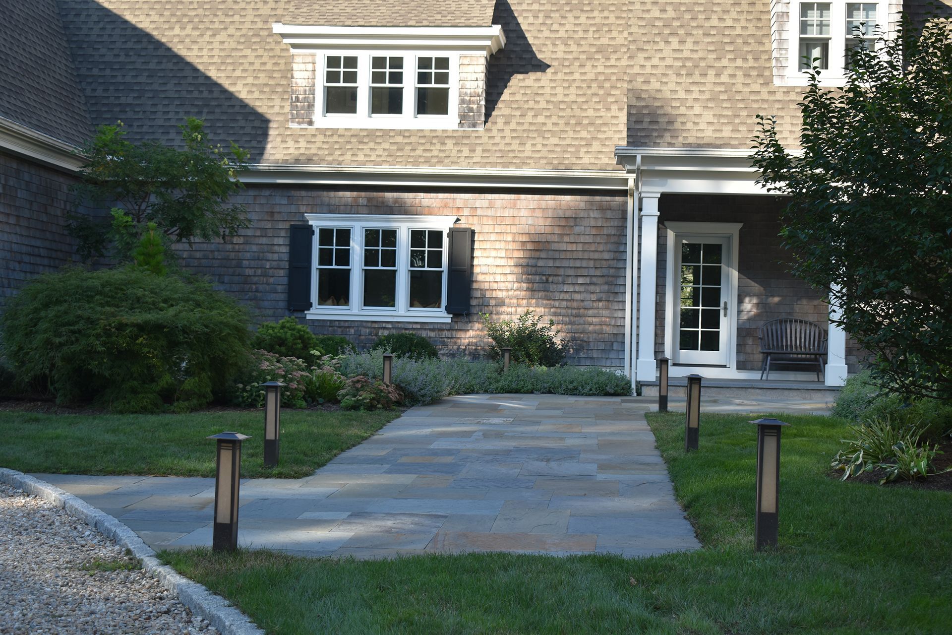 A brick house with a walkway leading to the front door