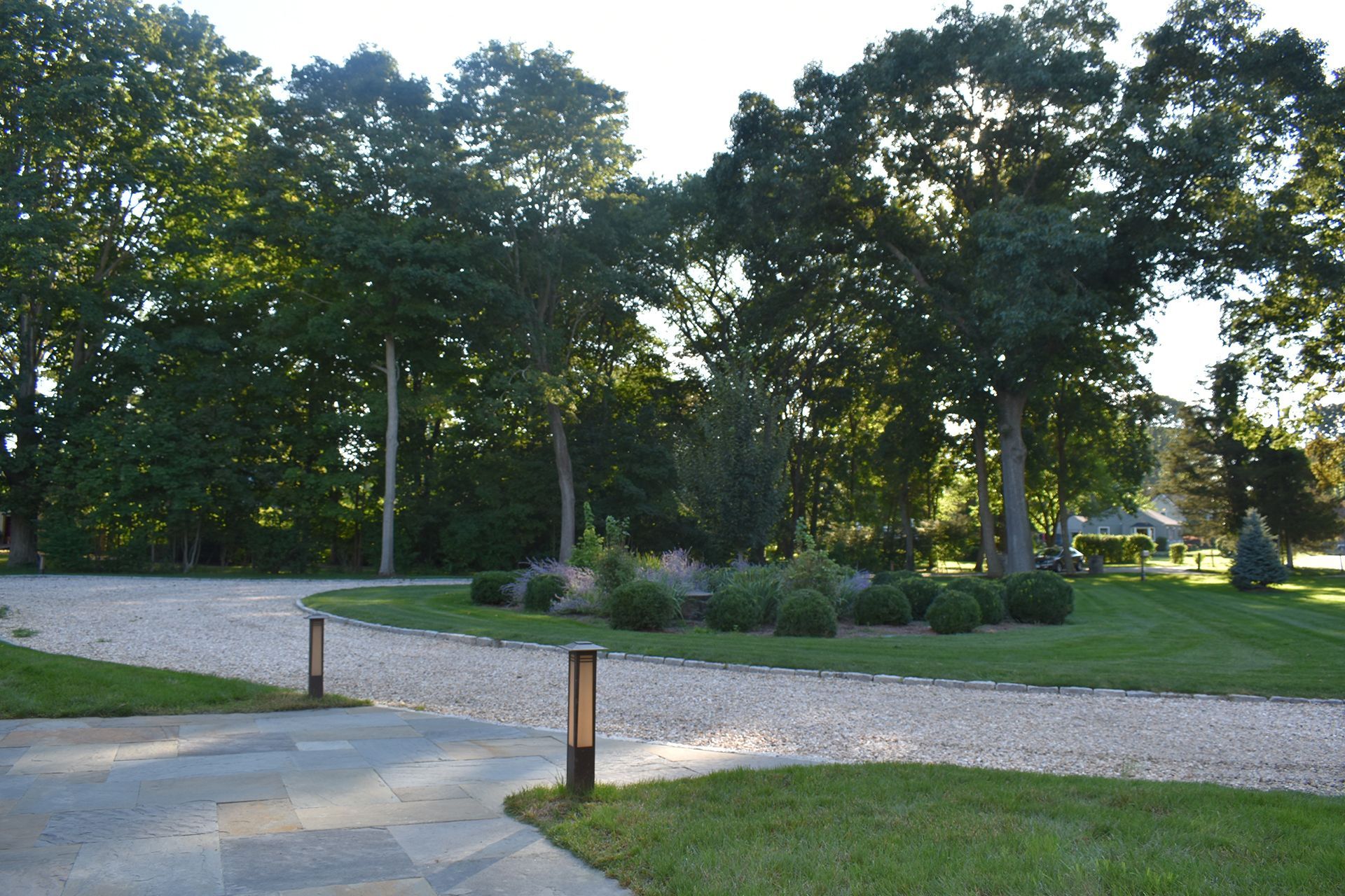 A gravel driveway with trees in the background