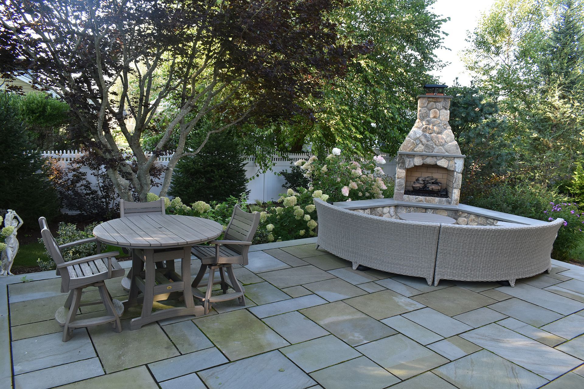 A patio with a table and chairs and a fireplace