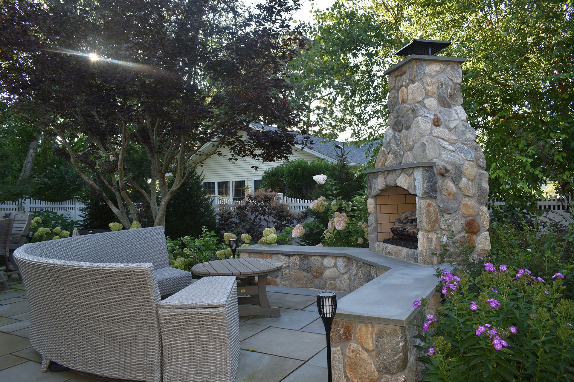 A patio with a stone fireplace and a couch
