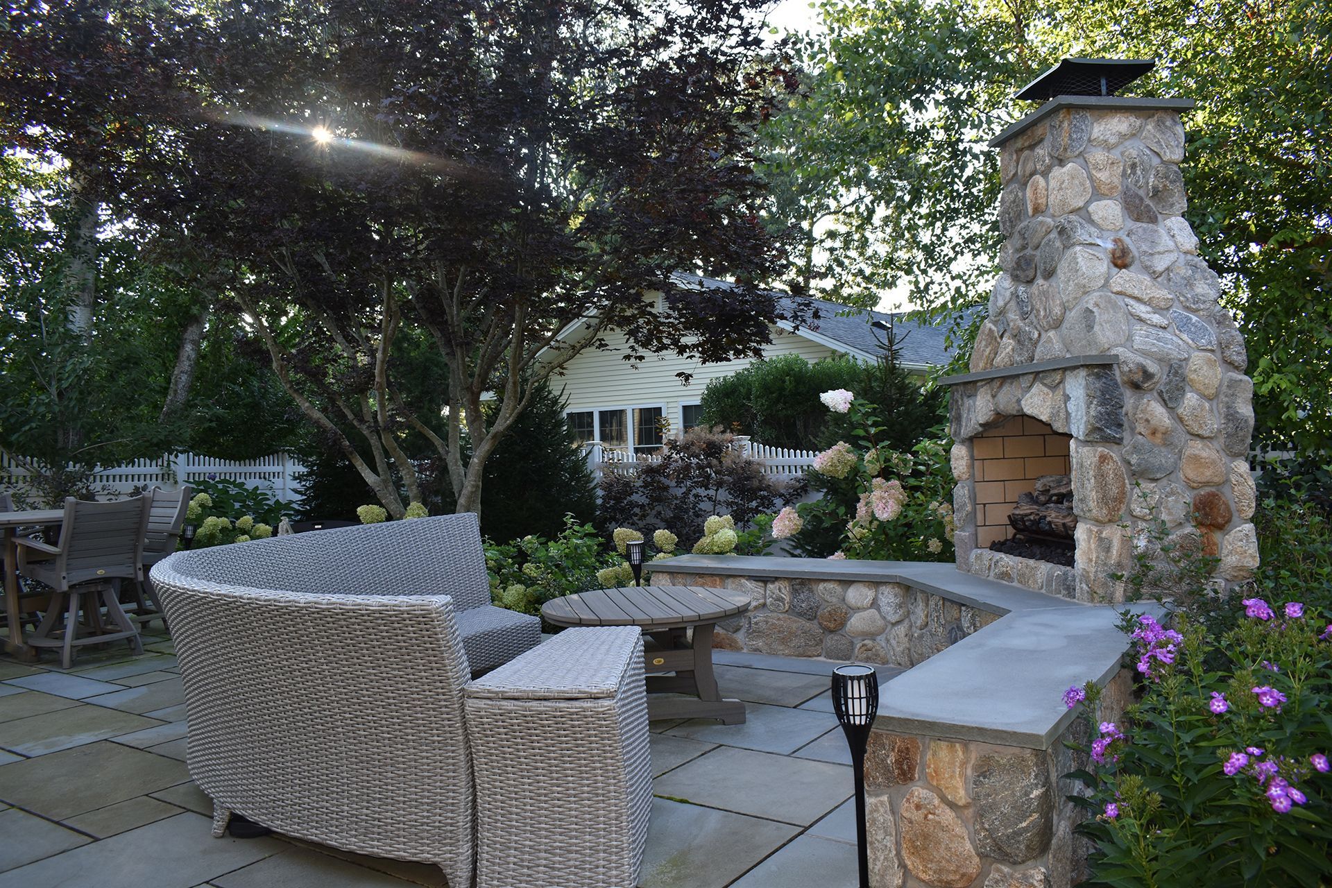 A patio with a fireplace and a couch and chairs