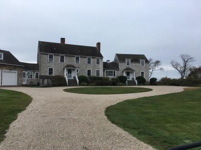 A large house with a gravel driveway leading to it