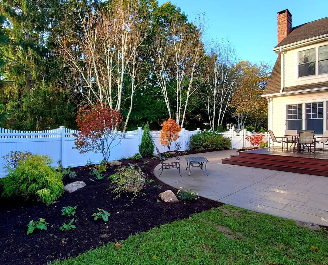 A house with a white fence and a patio in front of it