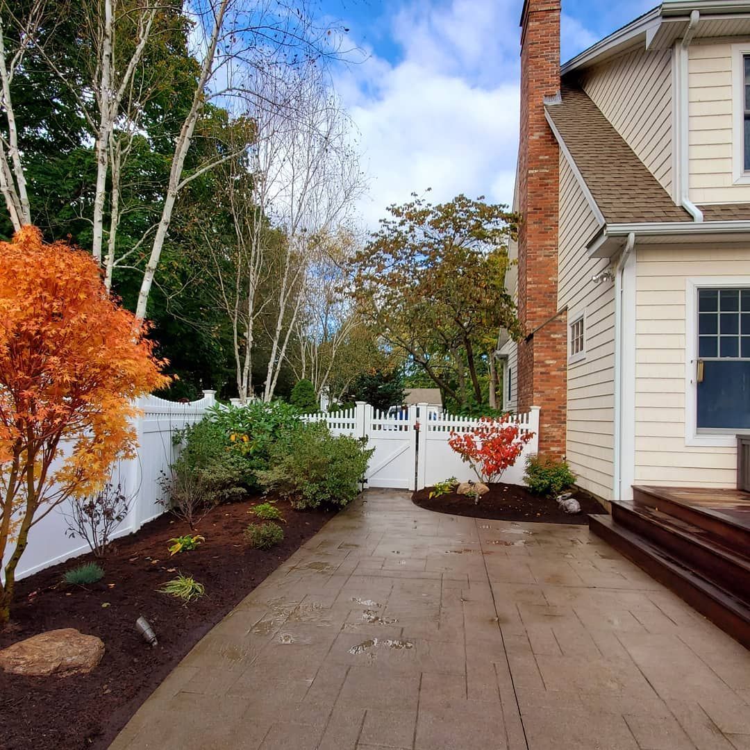 A house with a brick chimney is surrounded by trees and bushes