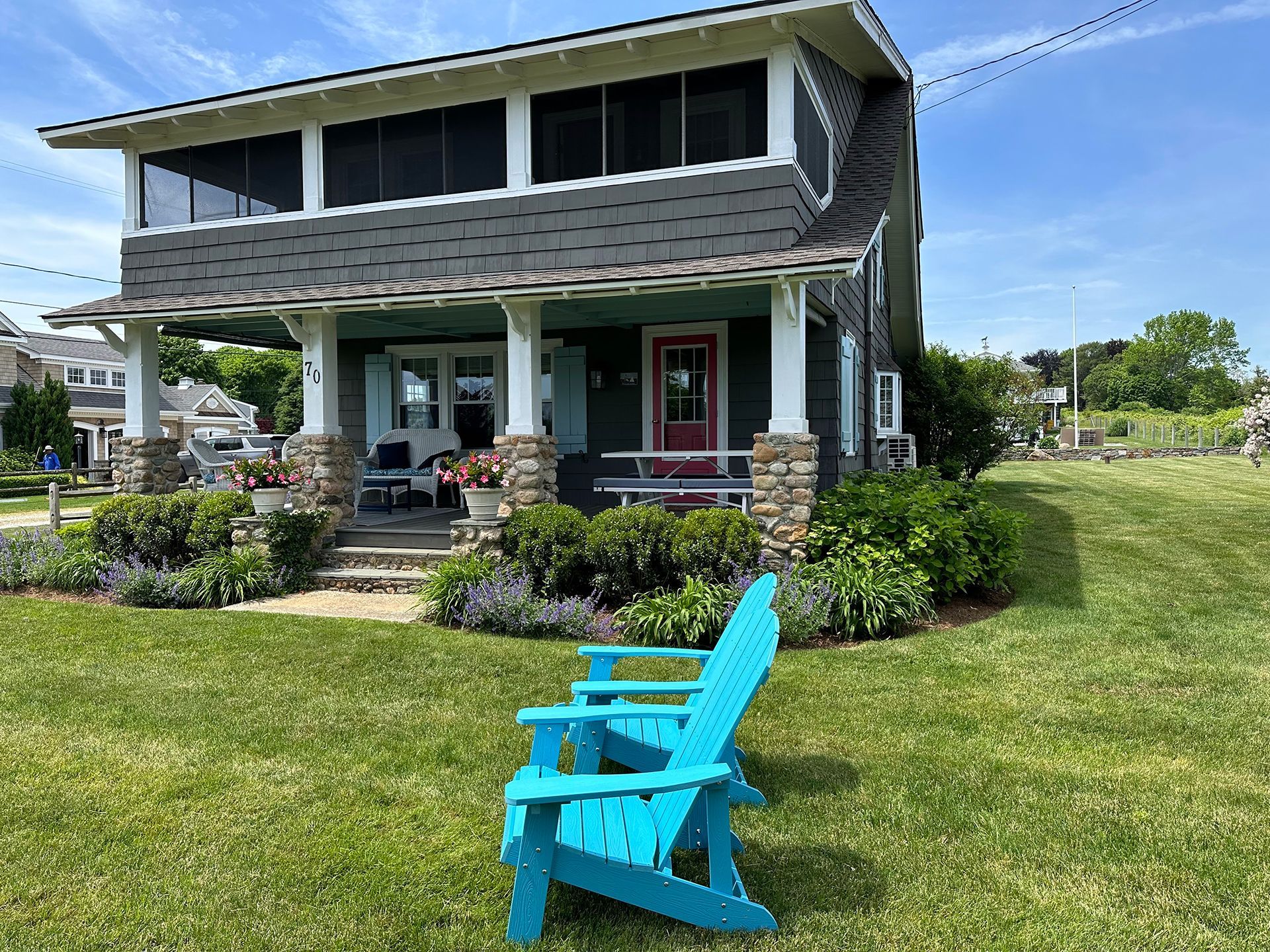 A blue chair is sitting in front of a house.