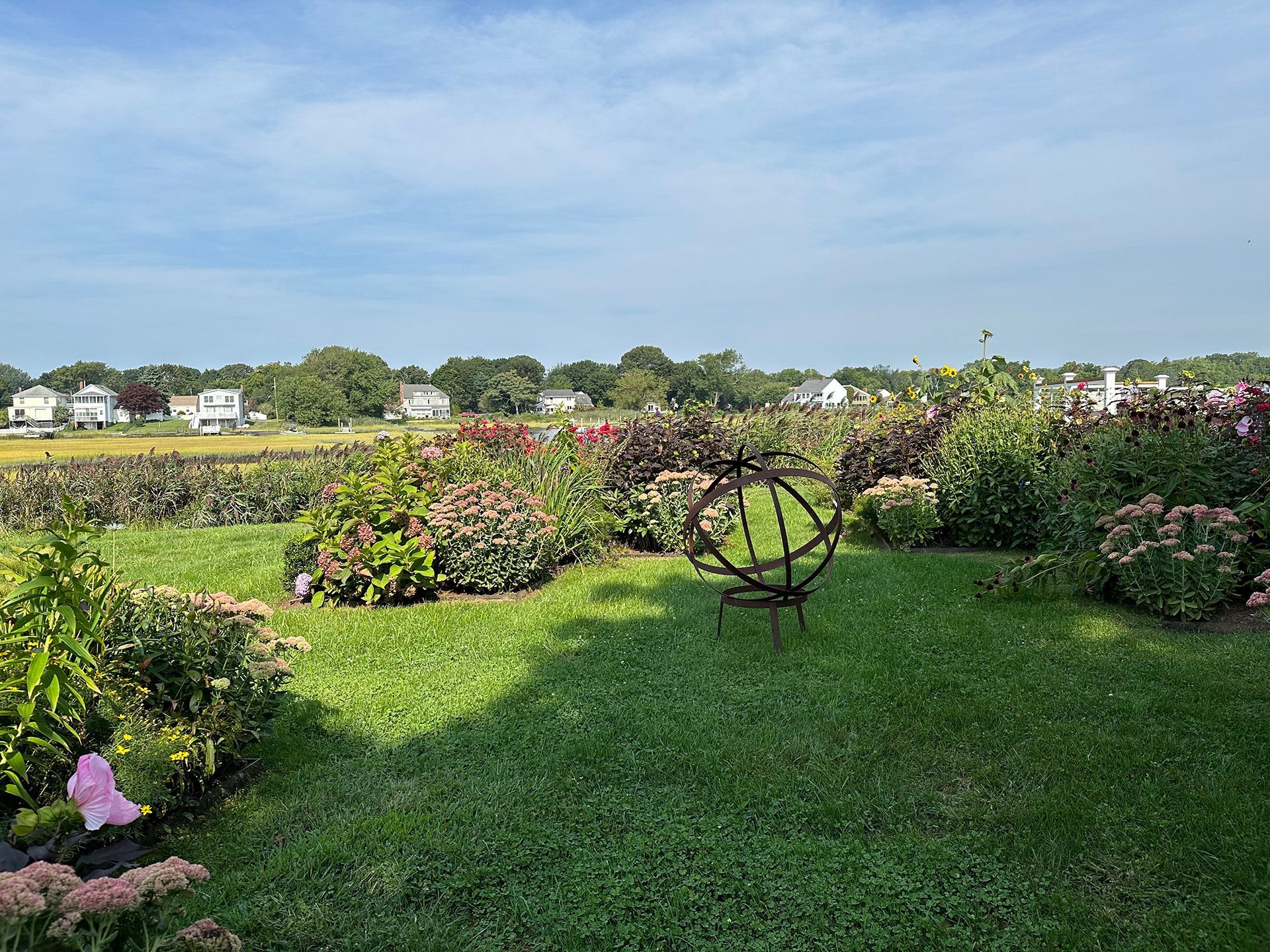 A garden with flowers and a sundial in the middle of it.