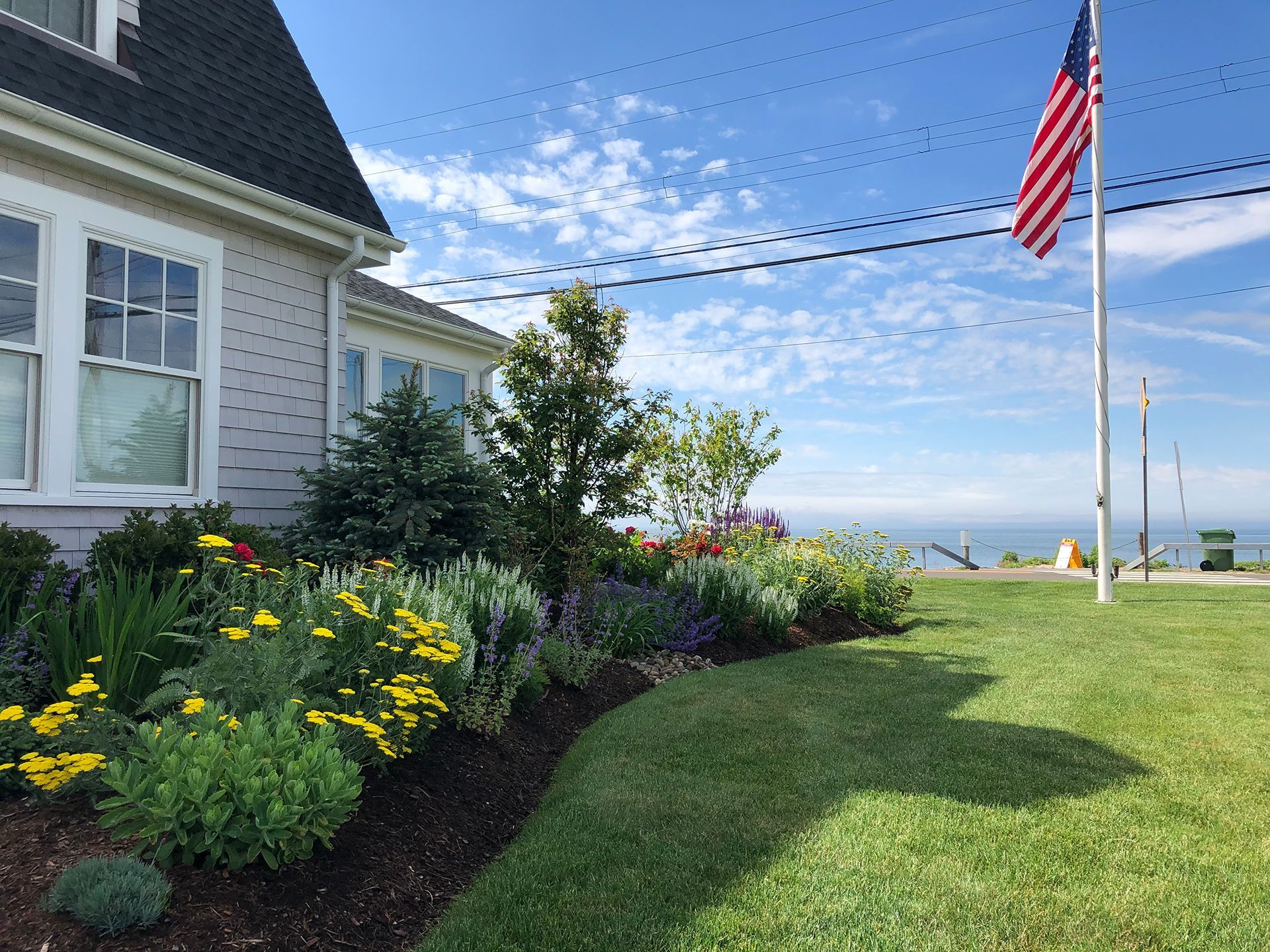 A house with a flag in front of it and a garden in front of it.