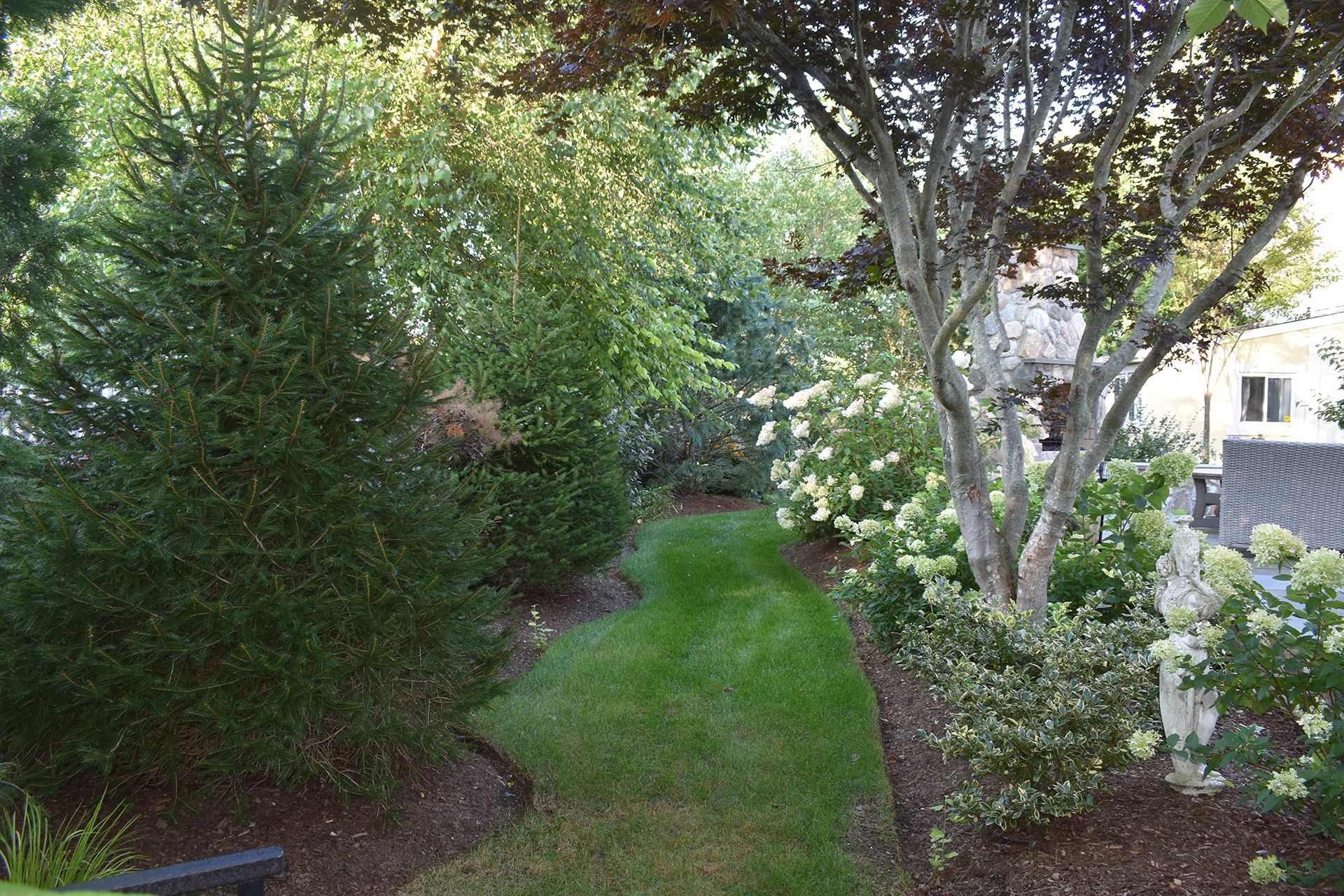 lush green lawn surrounded by trees and bushes.