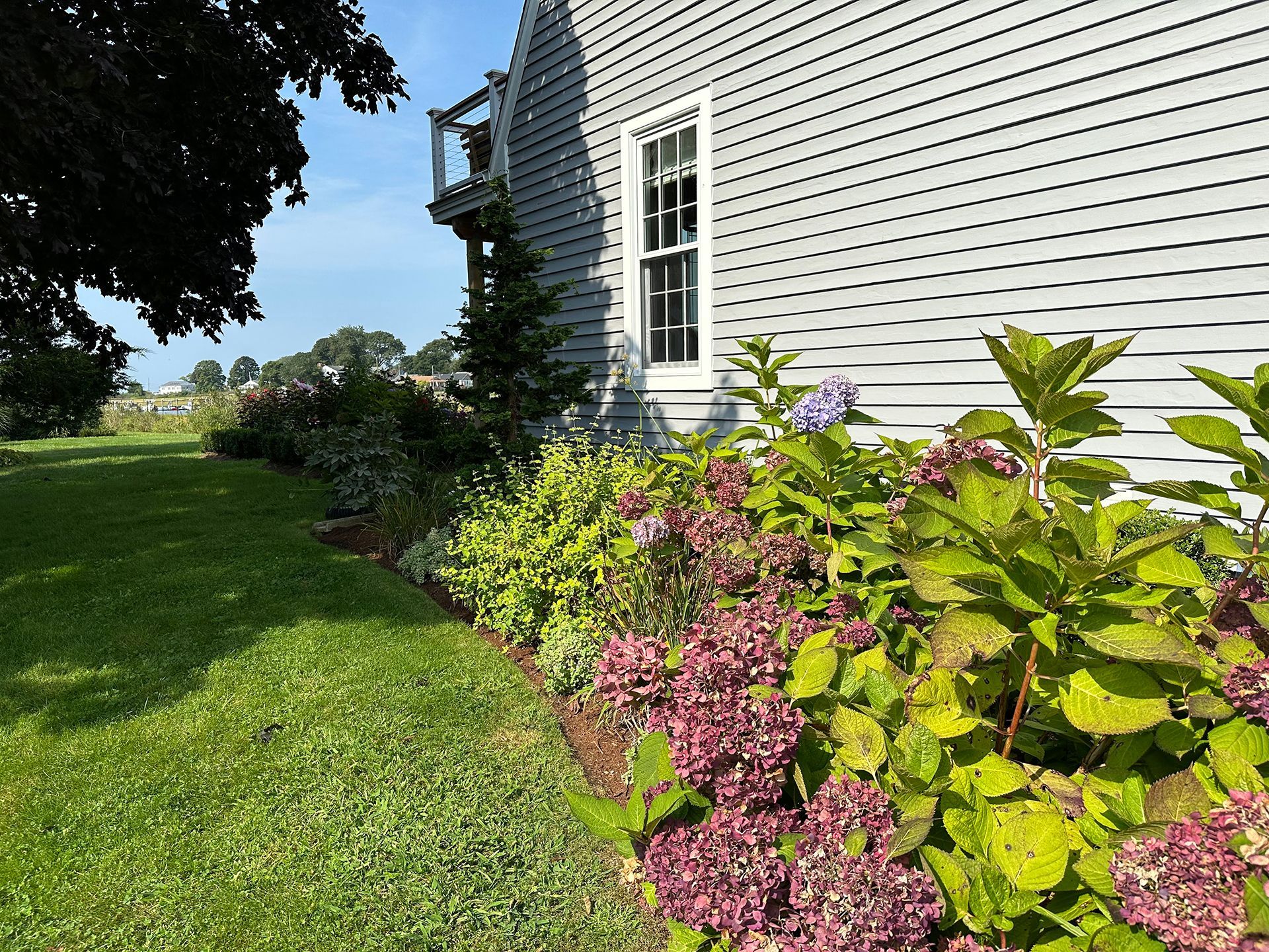 A house with a lot of flowers in front of it.