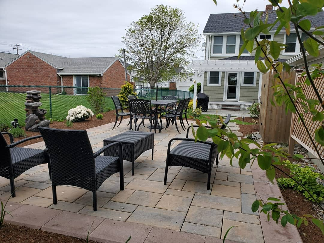 a patio with a table and chairs in front of a house .