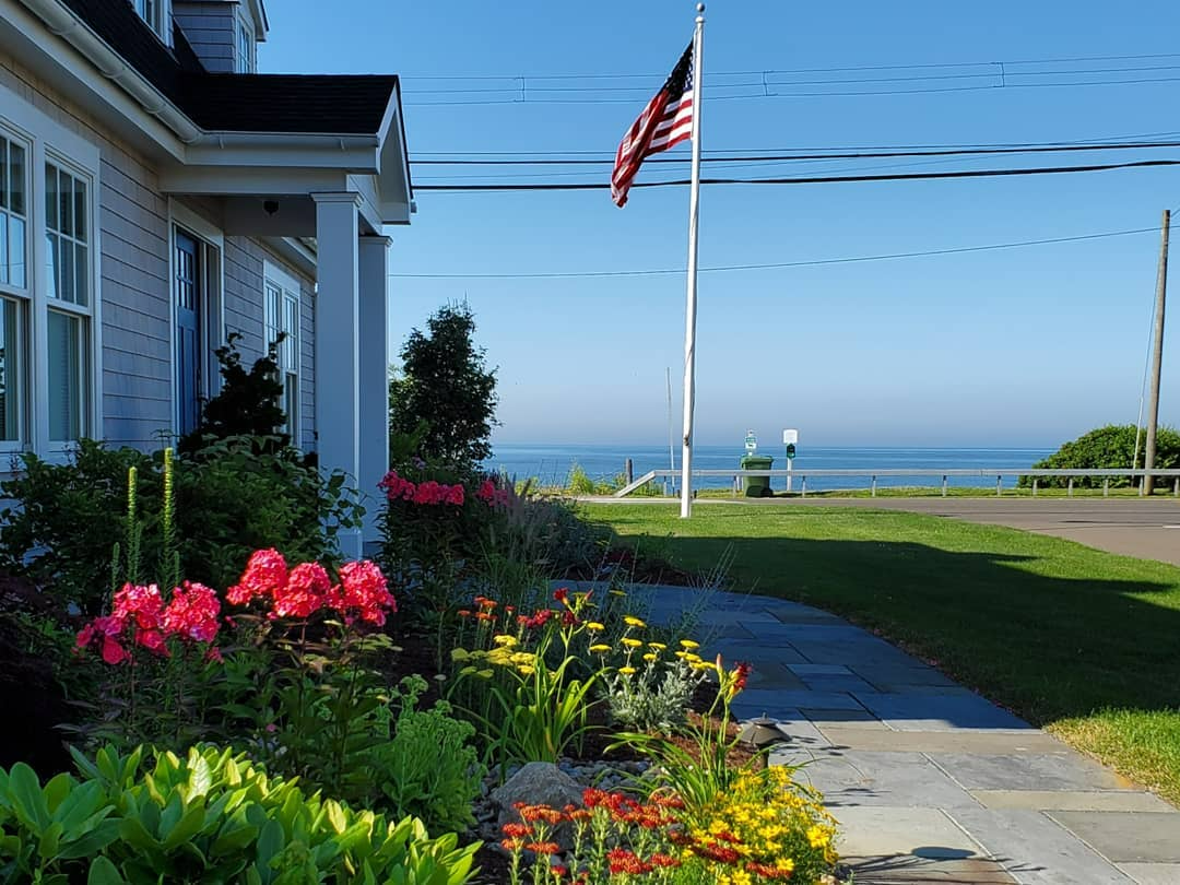 an american flag is flying in front of a house with a view of the ocean .