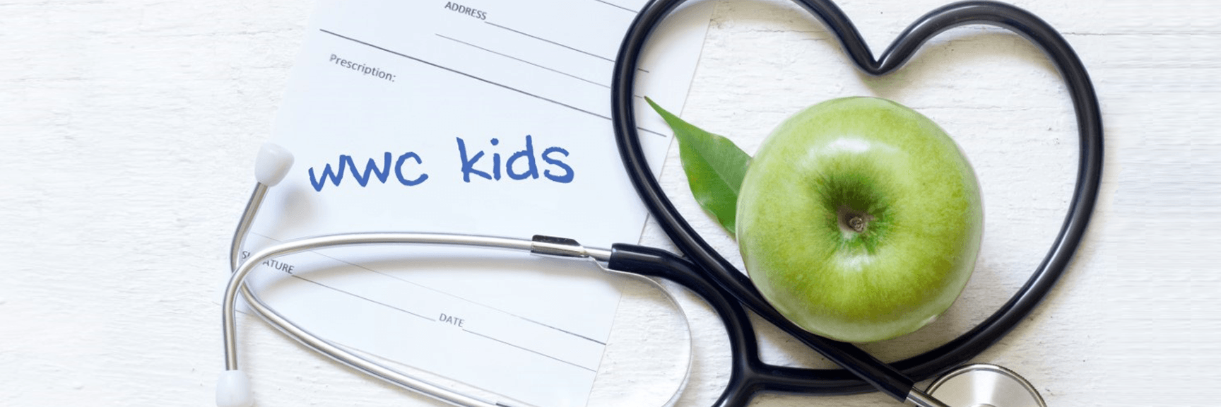 A green apple and a stethoscope in the shape of a heart.