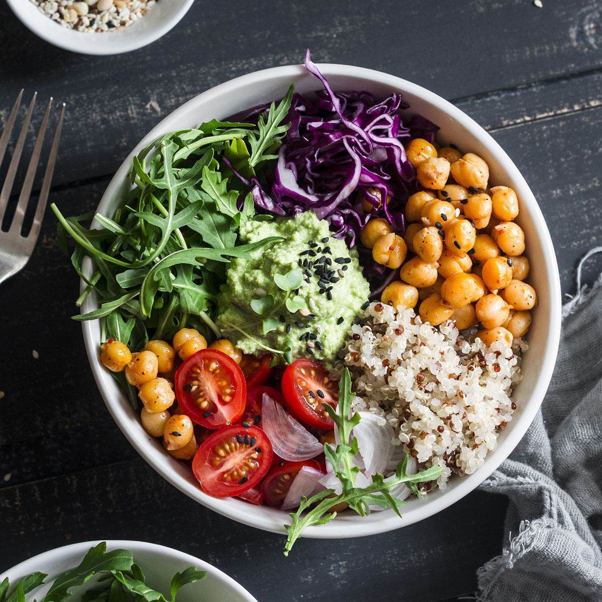 a bowl of food with chickpeas, tomatoes, cabbage, guacamole, and rice